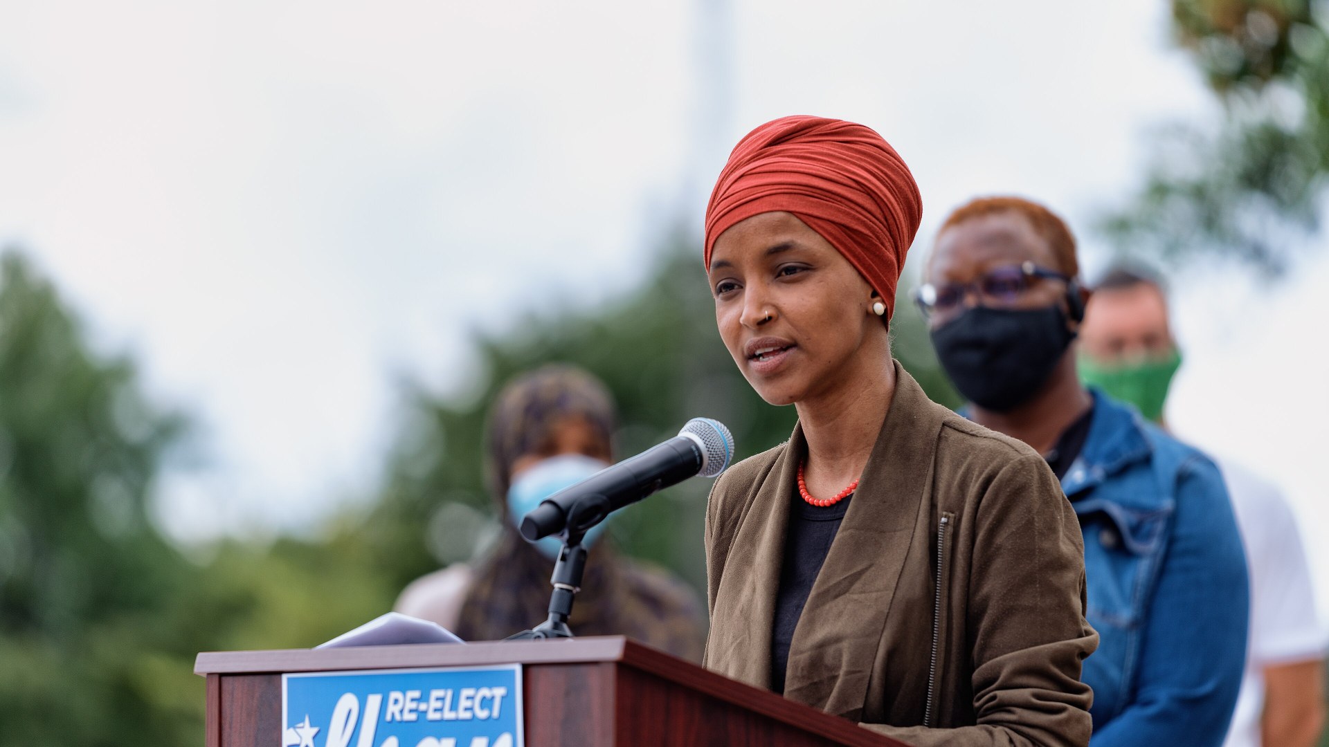 Rep. Ilhan Omar speaking at a Re-Elect Ilhan podium in Minnesota