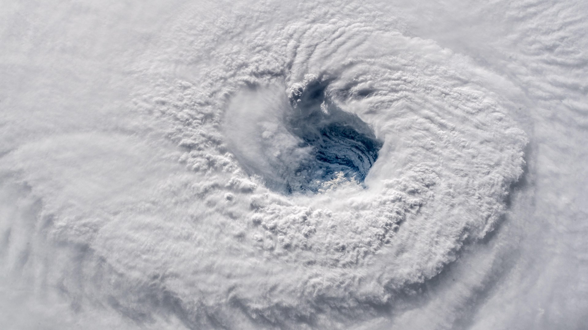 High-altitude orbital perspective staring directly into a compact, turbulent Category 5 hurricane eye.