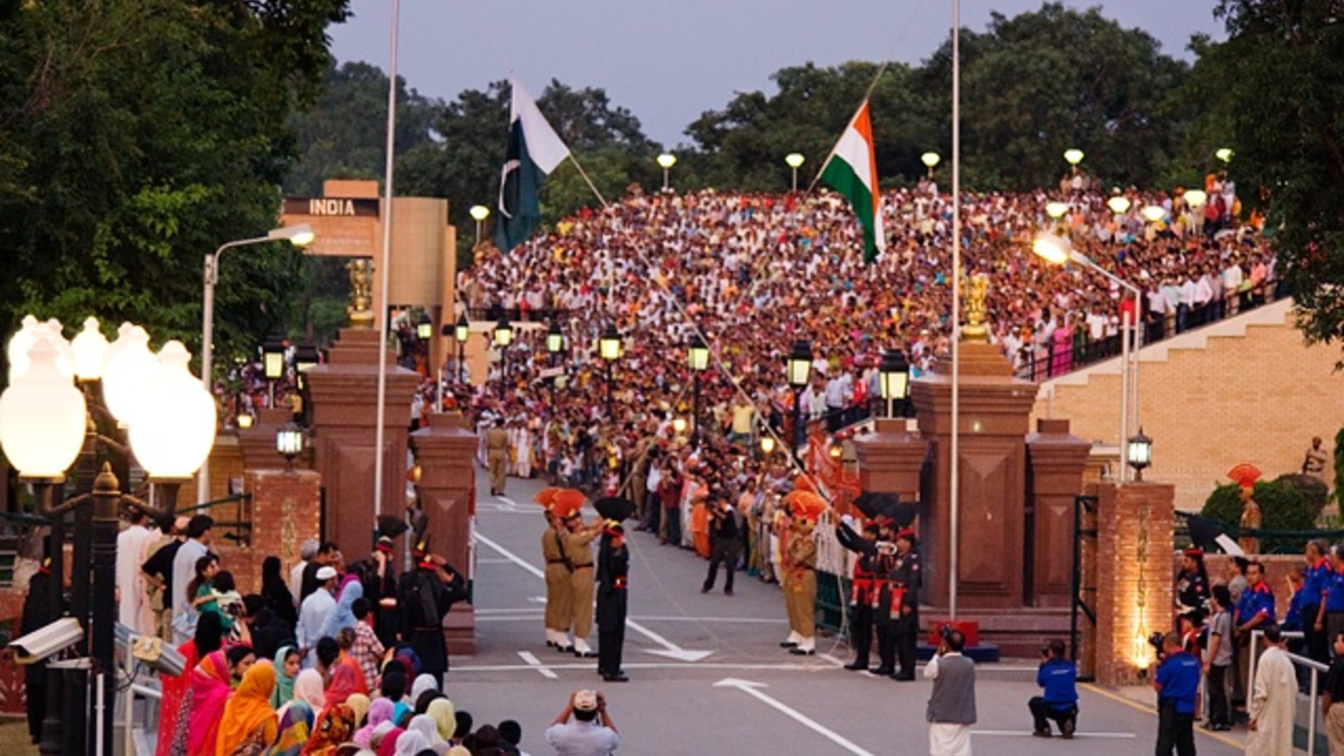 Landscape view of the evening flag-lowering ceremony and stadium crowds at the Wagah border crossing between India and Pakistan.
