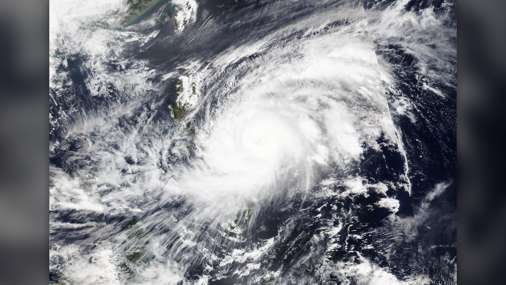 Wide-angle satellite capture of Super Typhoon Surigae spinning over the Philippine Sea in April 2021.