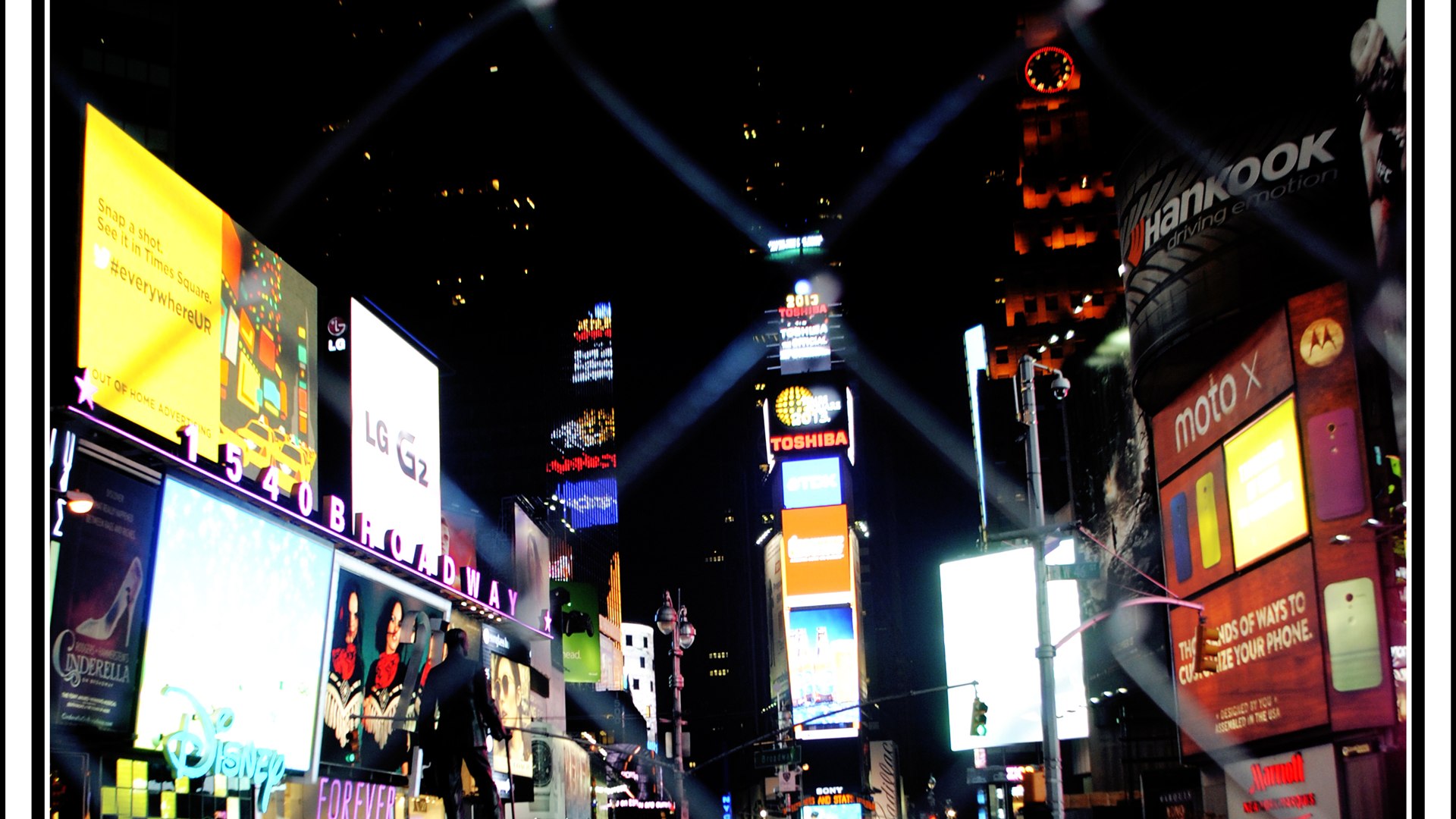 Times Square at night with towering neon and LED billboards lighting up the streets