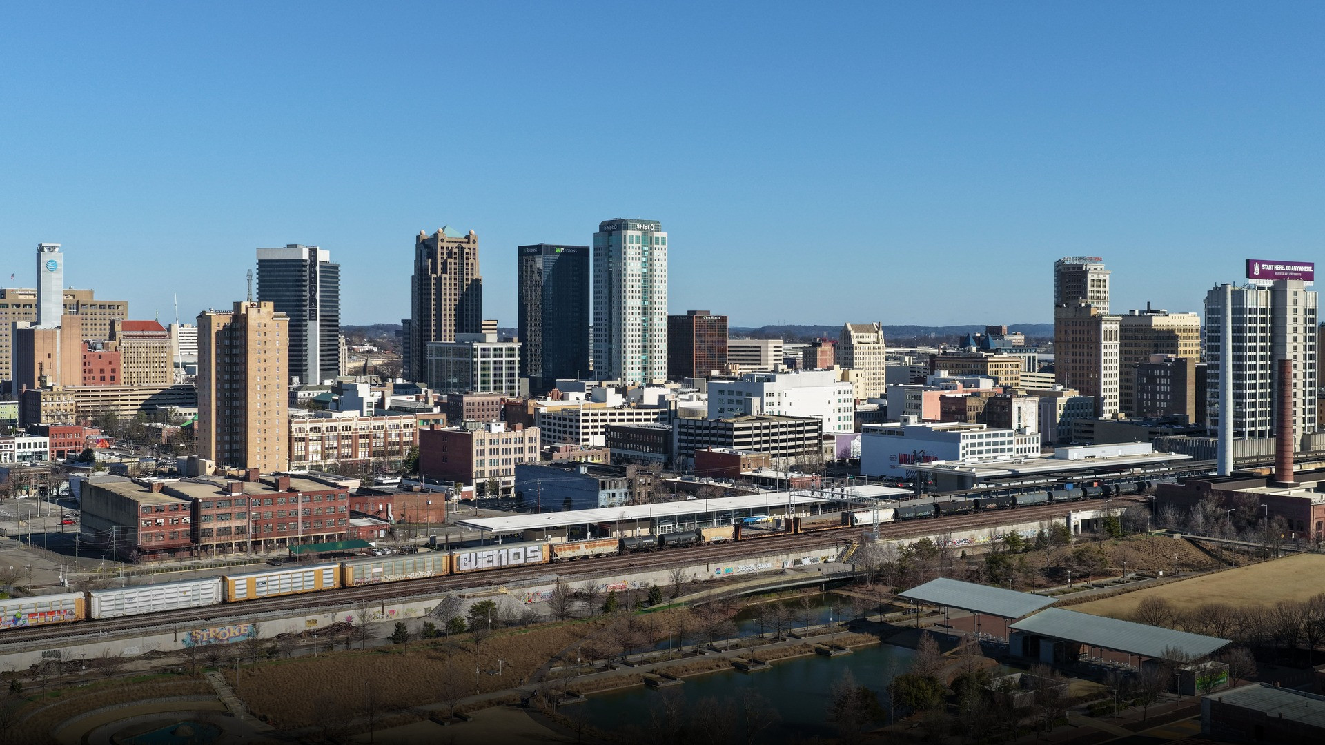 Panoramic view of downtown Birmingham Alabama skyline surrounded by lush green hills.
