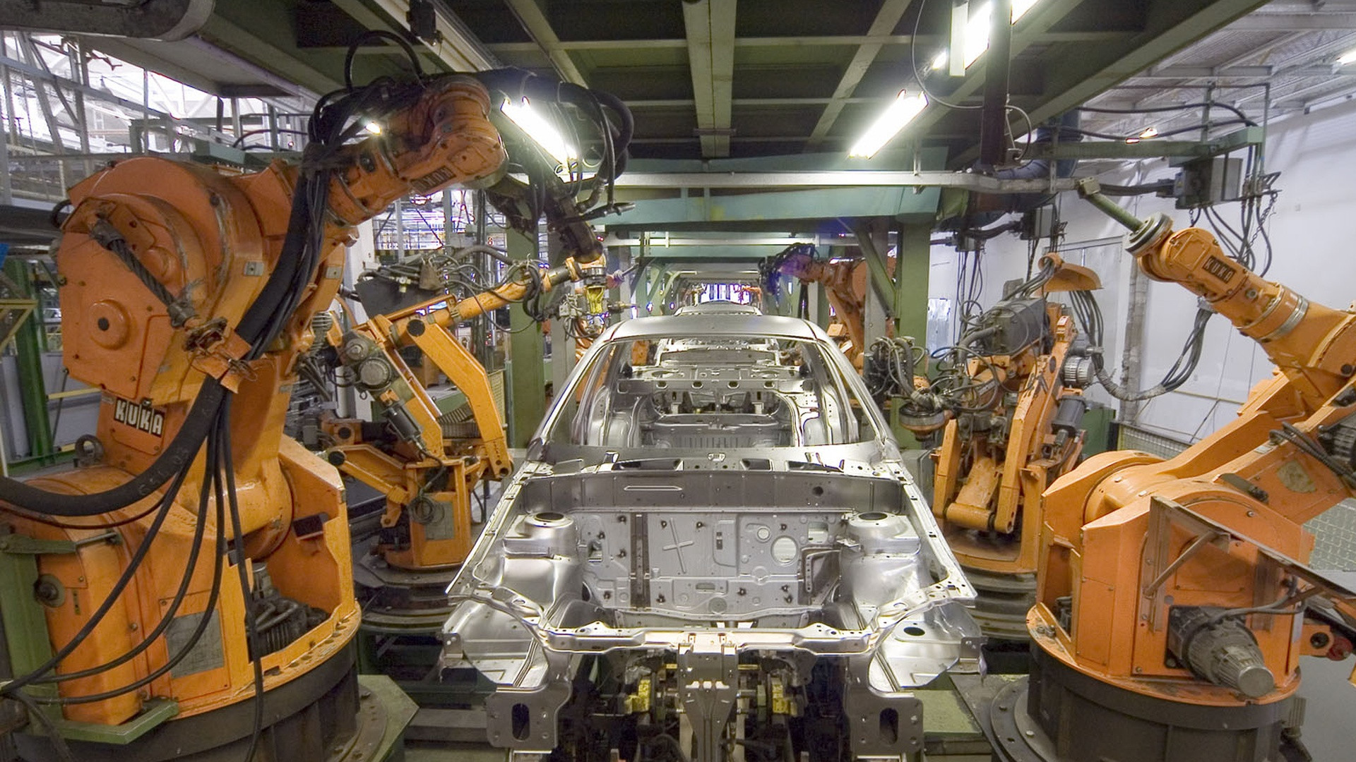 Heavy industrial robotics working on automated manufacturing line.