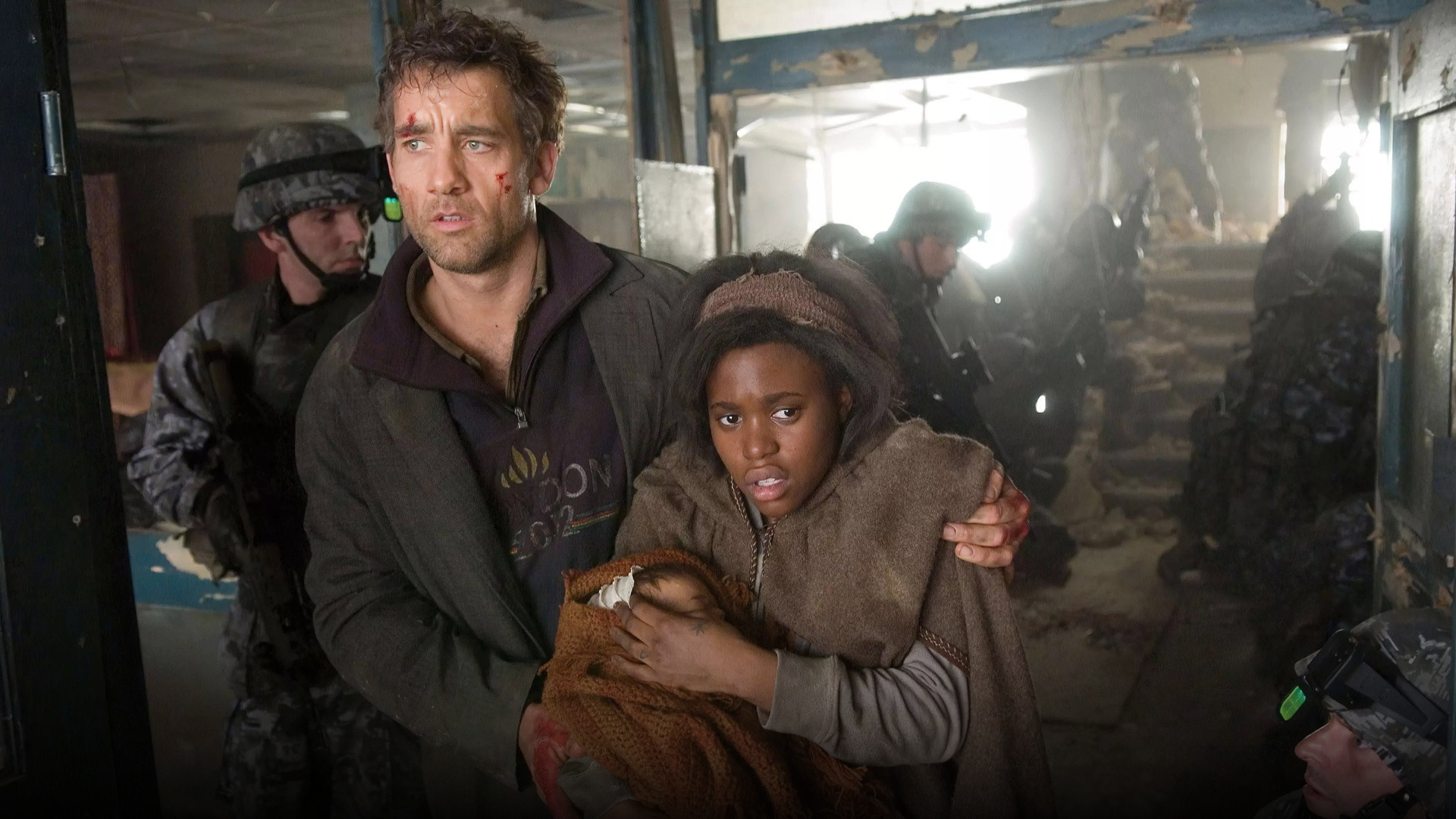 Theo Faron protecting Kee and her newborn baby while moving through a ruined warzone in Children of Men.