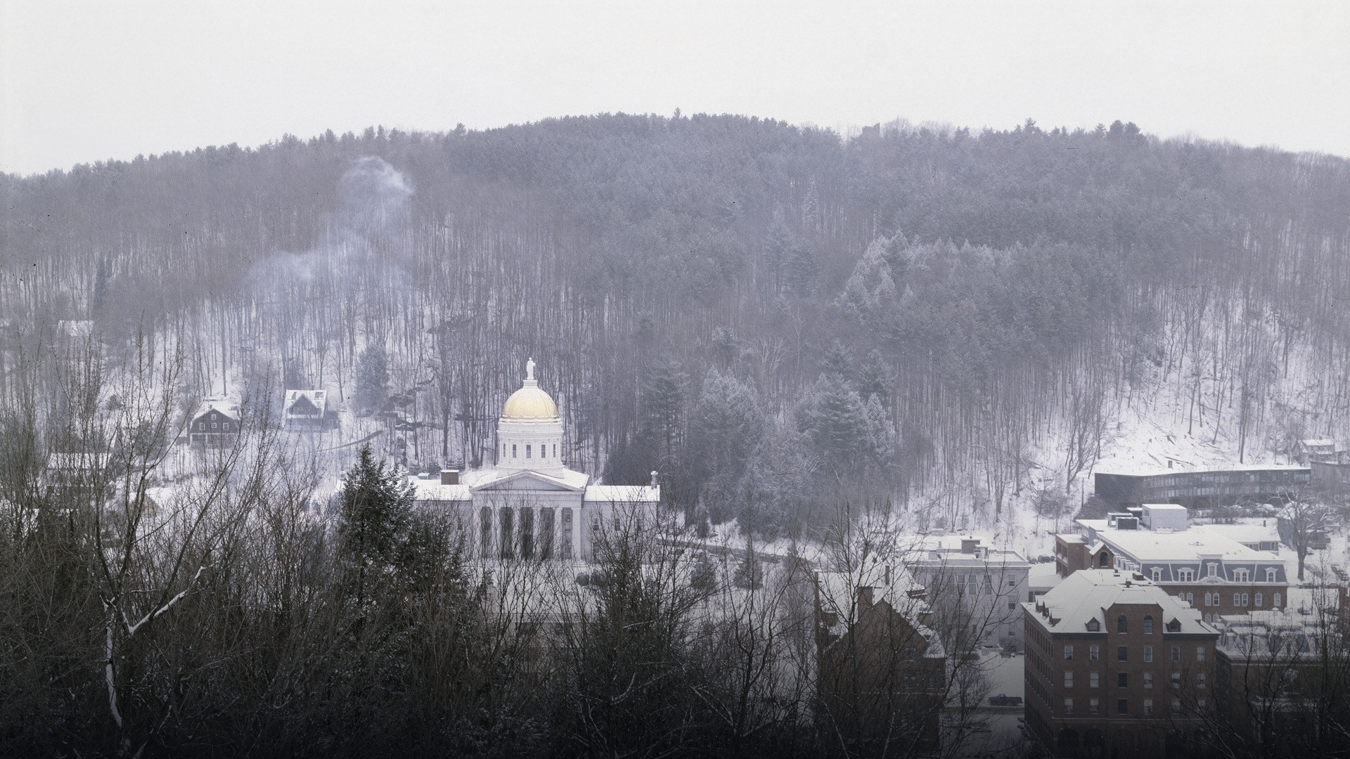 The Vermont State House with its gold dome surrounded by deep snow in Montpelier.