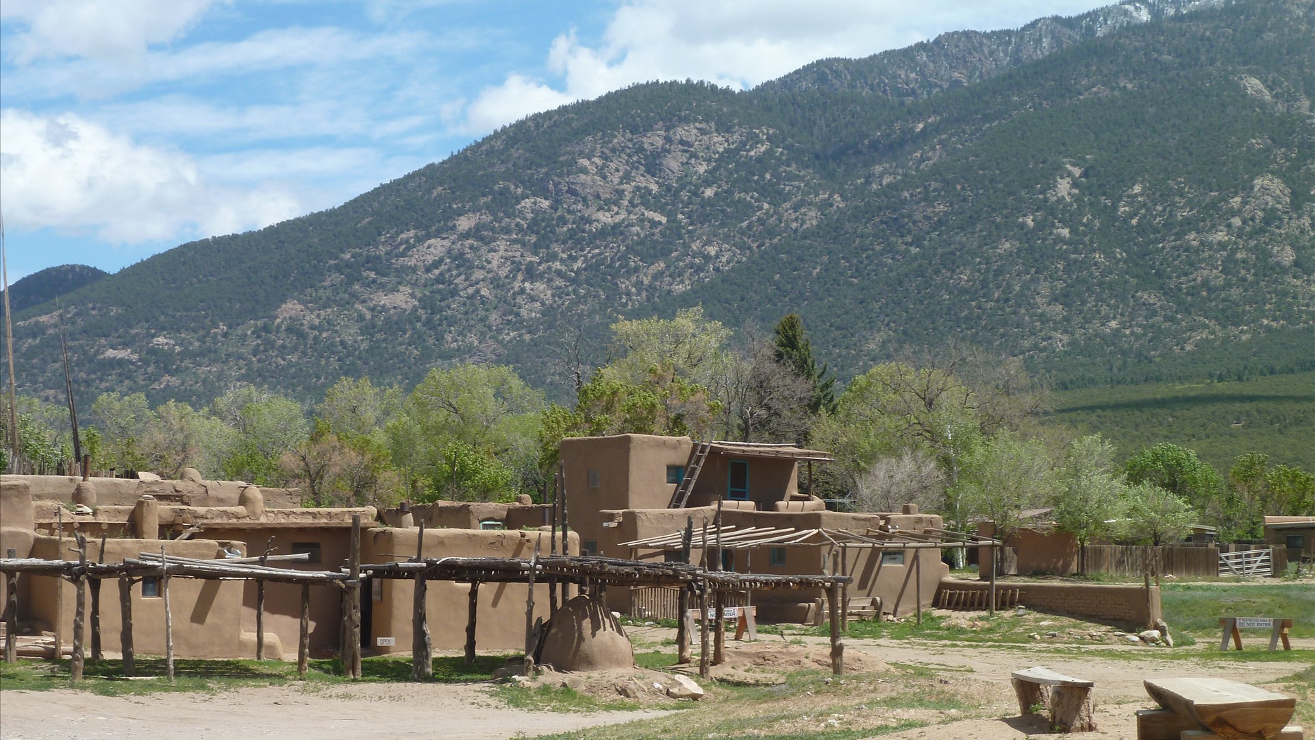 Multi-story adobe buildings of Taos Pueblo beneath the Sangre de Cristo Mountains in Taos, New Mexico