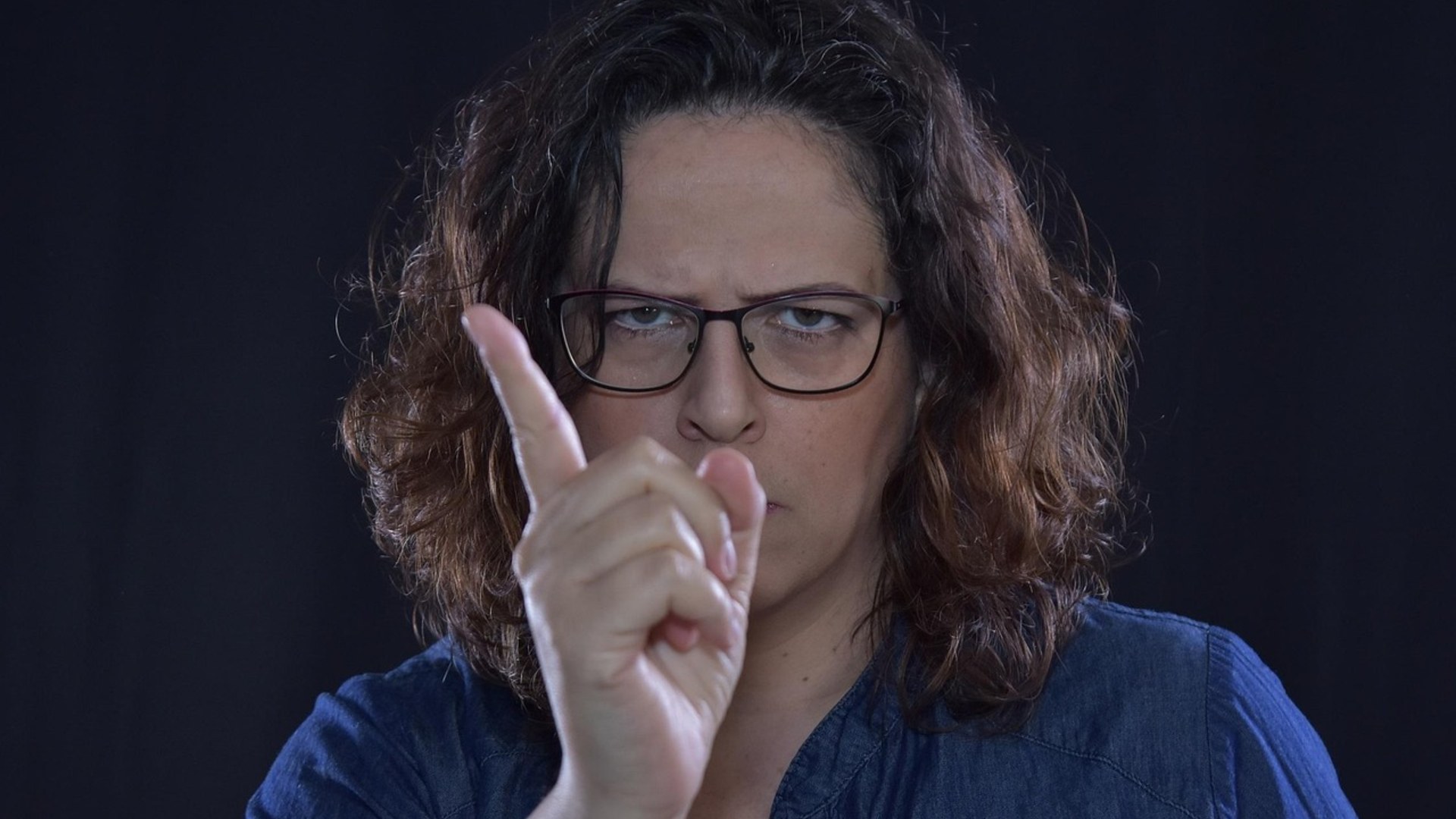 Woman pointing an accusing finger critically at the camera