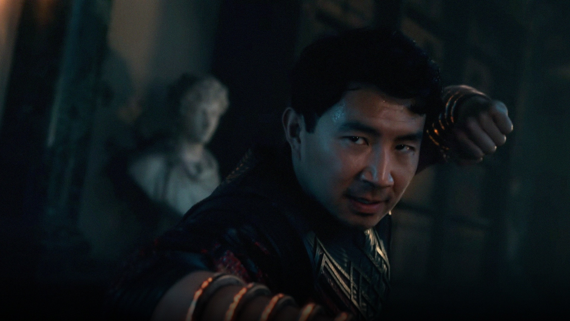 Simu Liu as Shang-Chi wielding the glowing Ten Rings in dynamic martial arts stance.