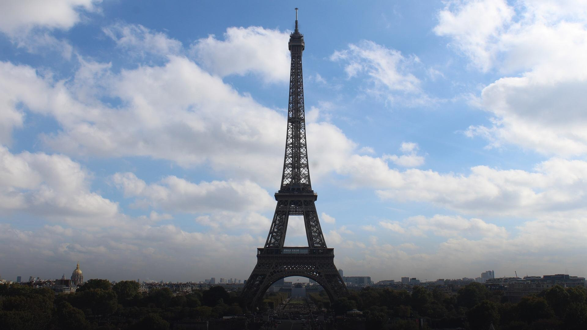 The complete Eiffel Tower soaring from base arches to antenna tip above the Champ de Mars and Trocadéro.