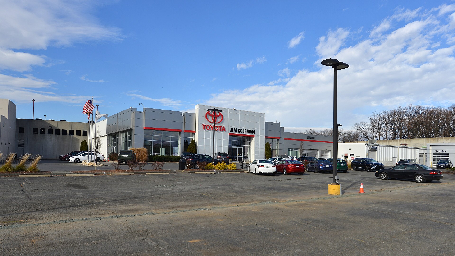 Rows of new vehicles parked at an automotive dealership lot