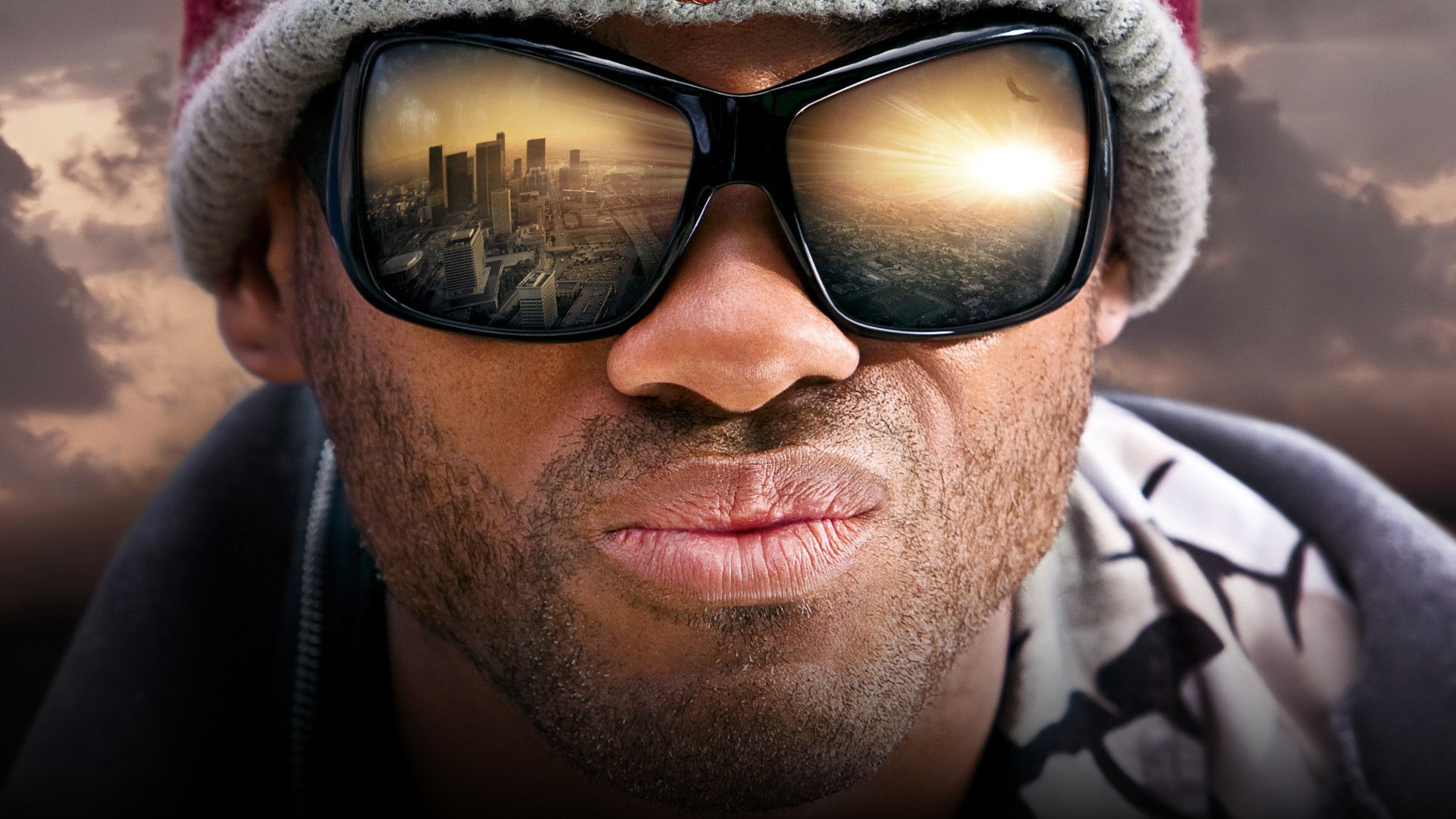 Will Smith as John Hancock in sunglasses and a scruffy beanie floating over Los Angeles with an unbothered expression
