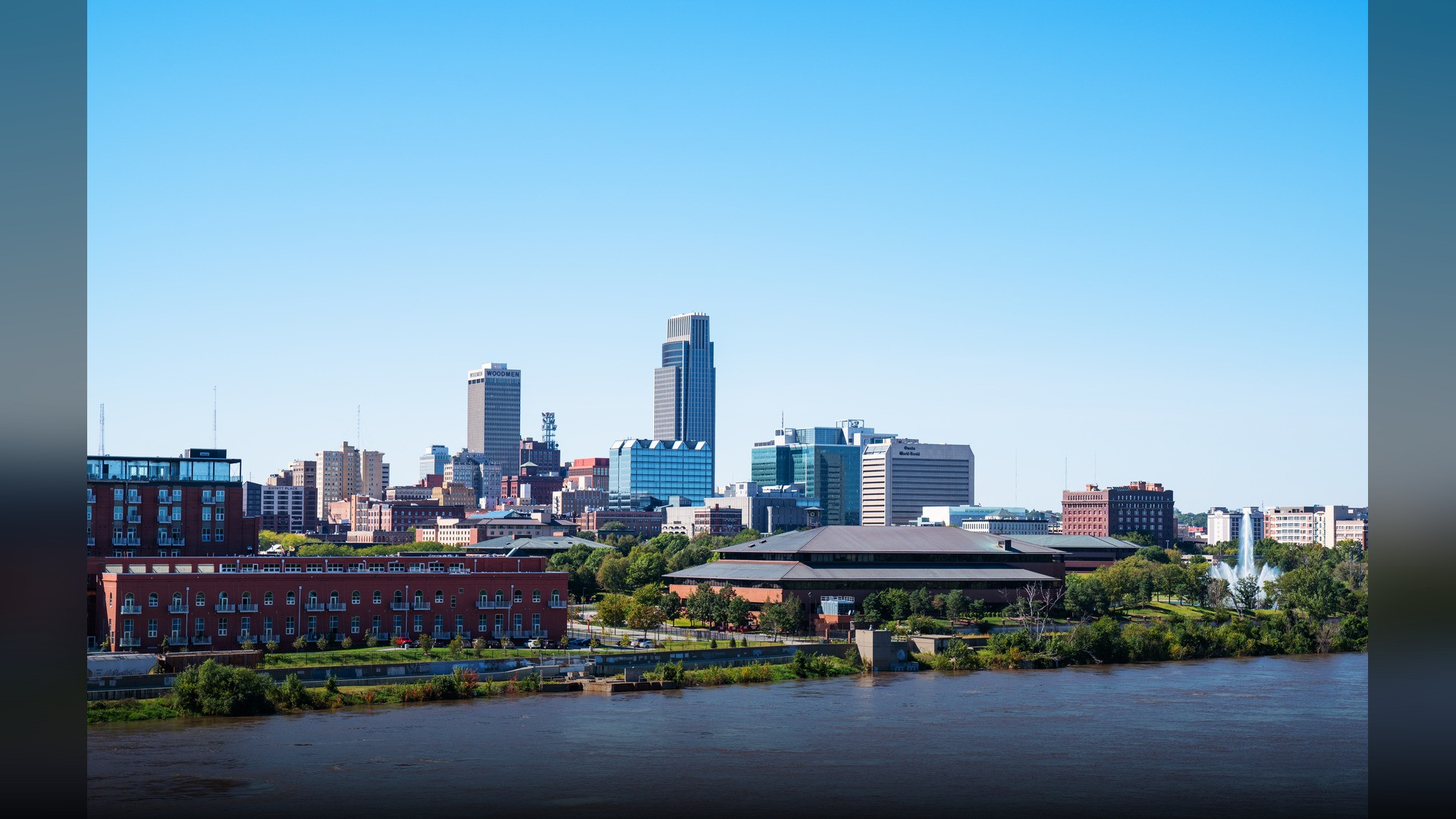 Downtown Omaha Nebraska skyline overlooking the Missouri River waterfront at twilight.