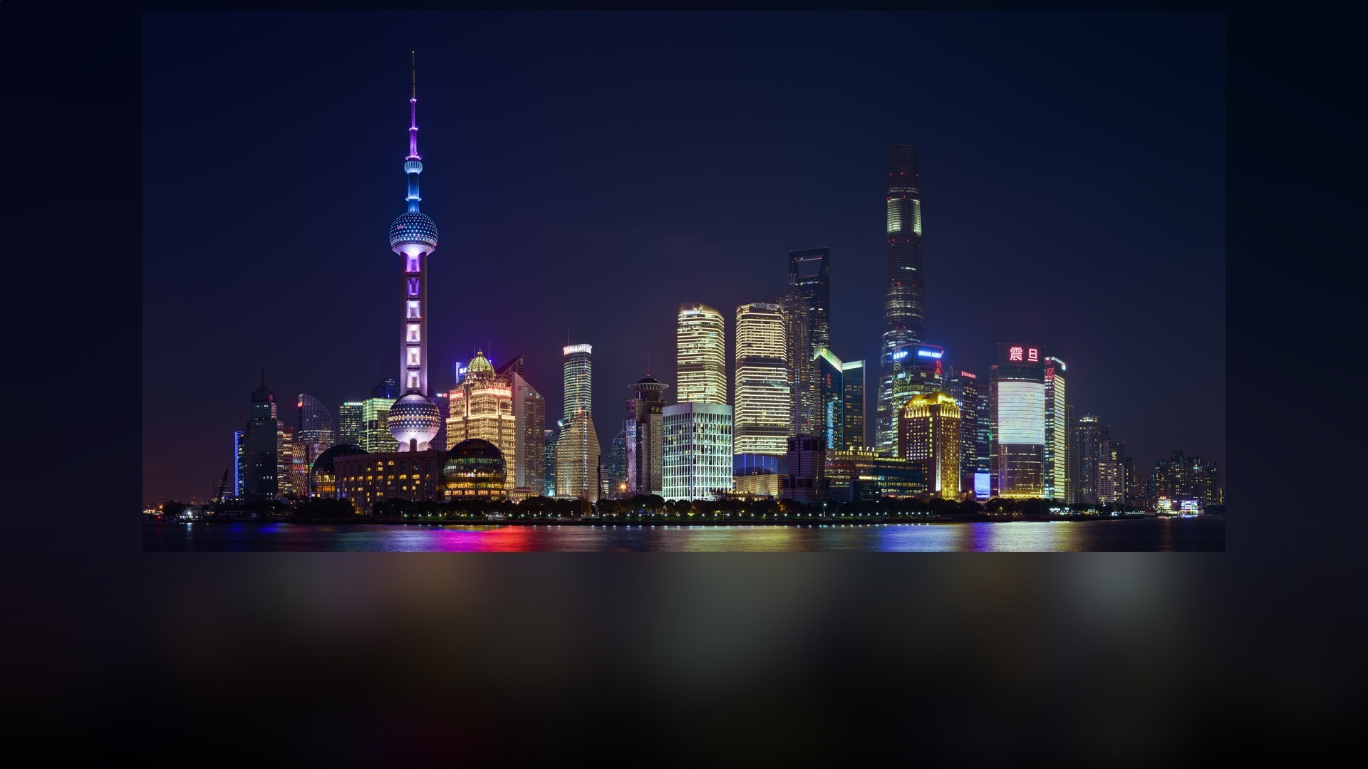 The futuristic Pudong skyline in Shanghai, China illuminated at night.