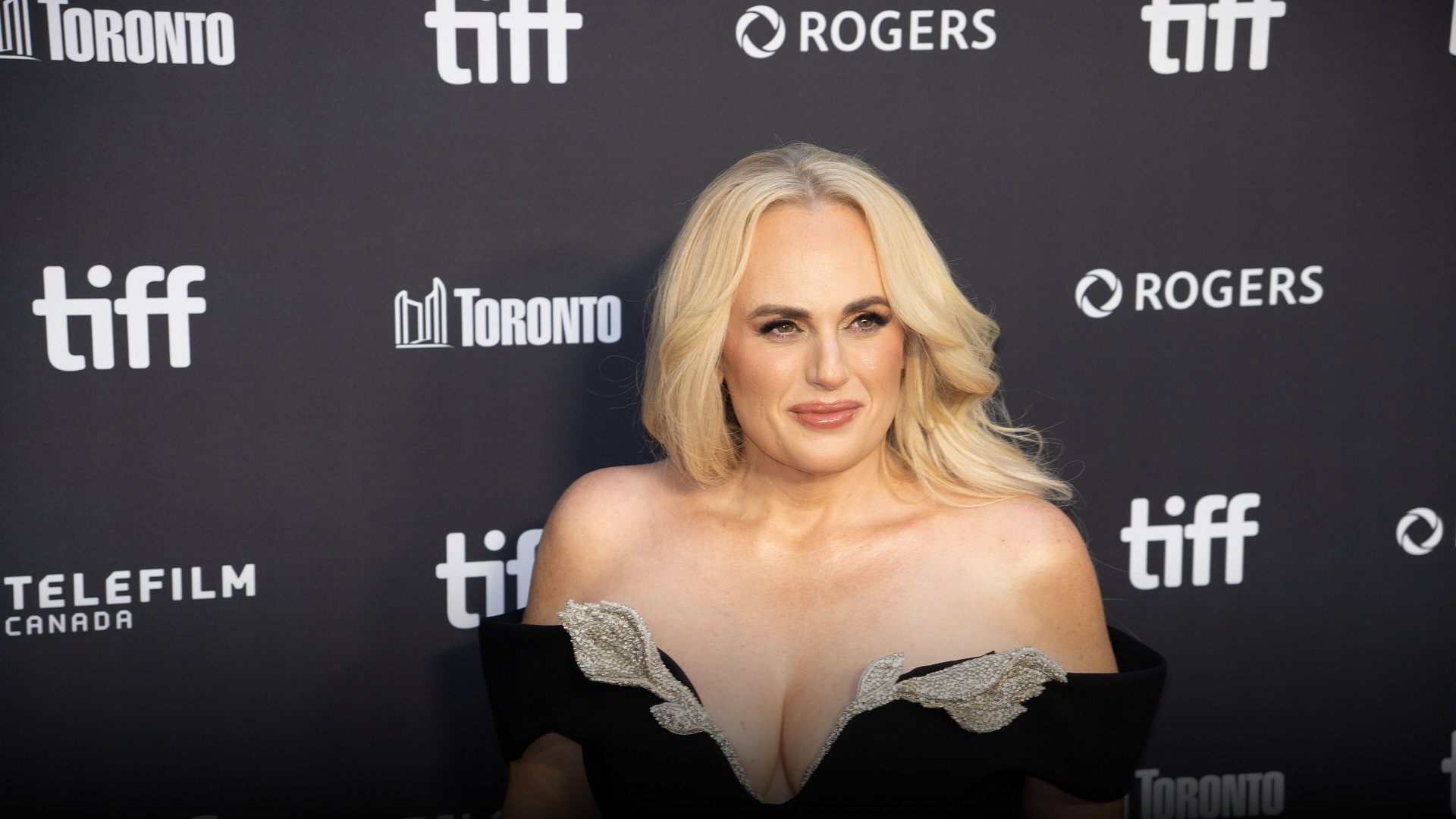 High-resolution portrait photograph of Rebel Wilson celebrating academic achievement.