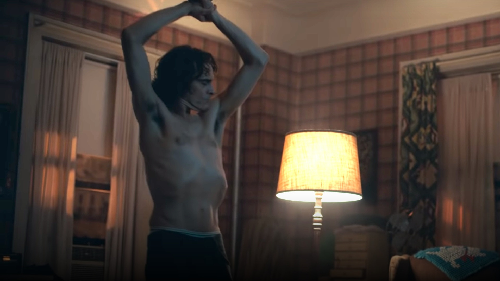 Joaquin Phoenix shirtless with visibly protruding ribcage and sunken waist in Joker.