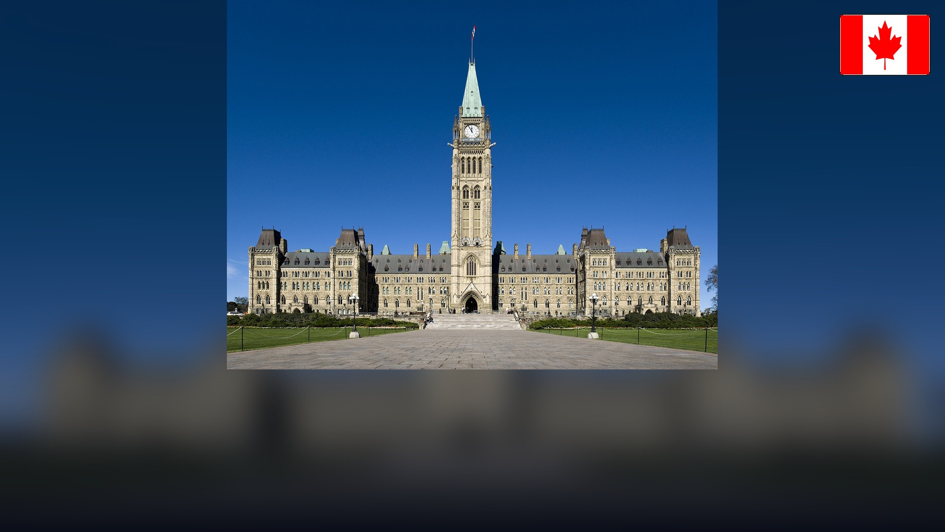 Parliament Hill Centre Block and Peace Tower in Ottawa with the Canadian flag in the top right corner.