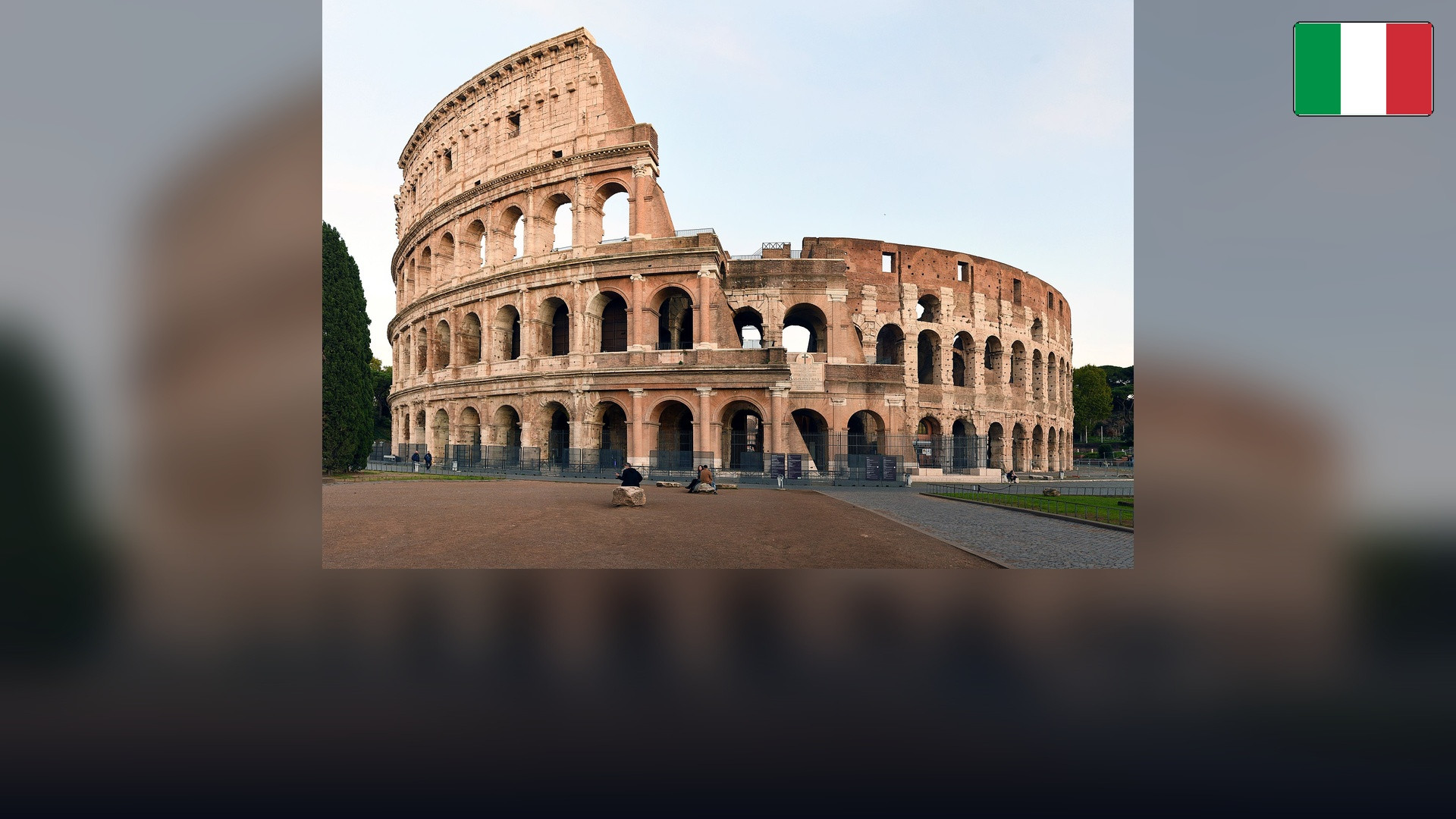 Colosseum in Rome with the Italian flag in the top right corner.
