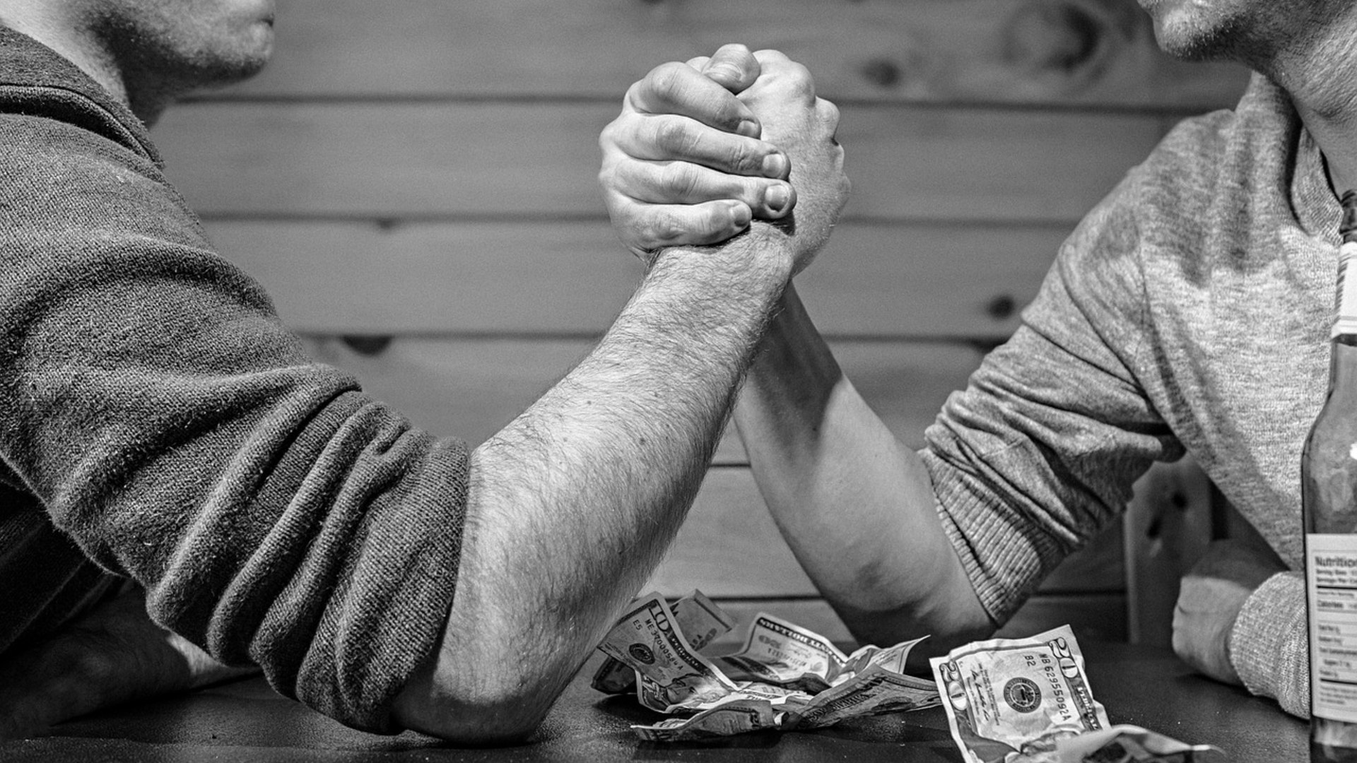 Two people locked in an intense arm wrestling match