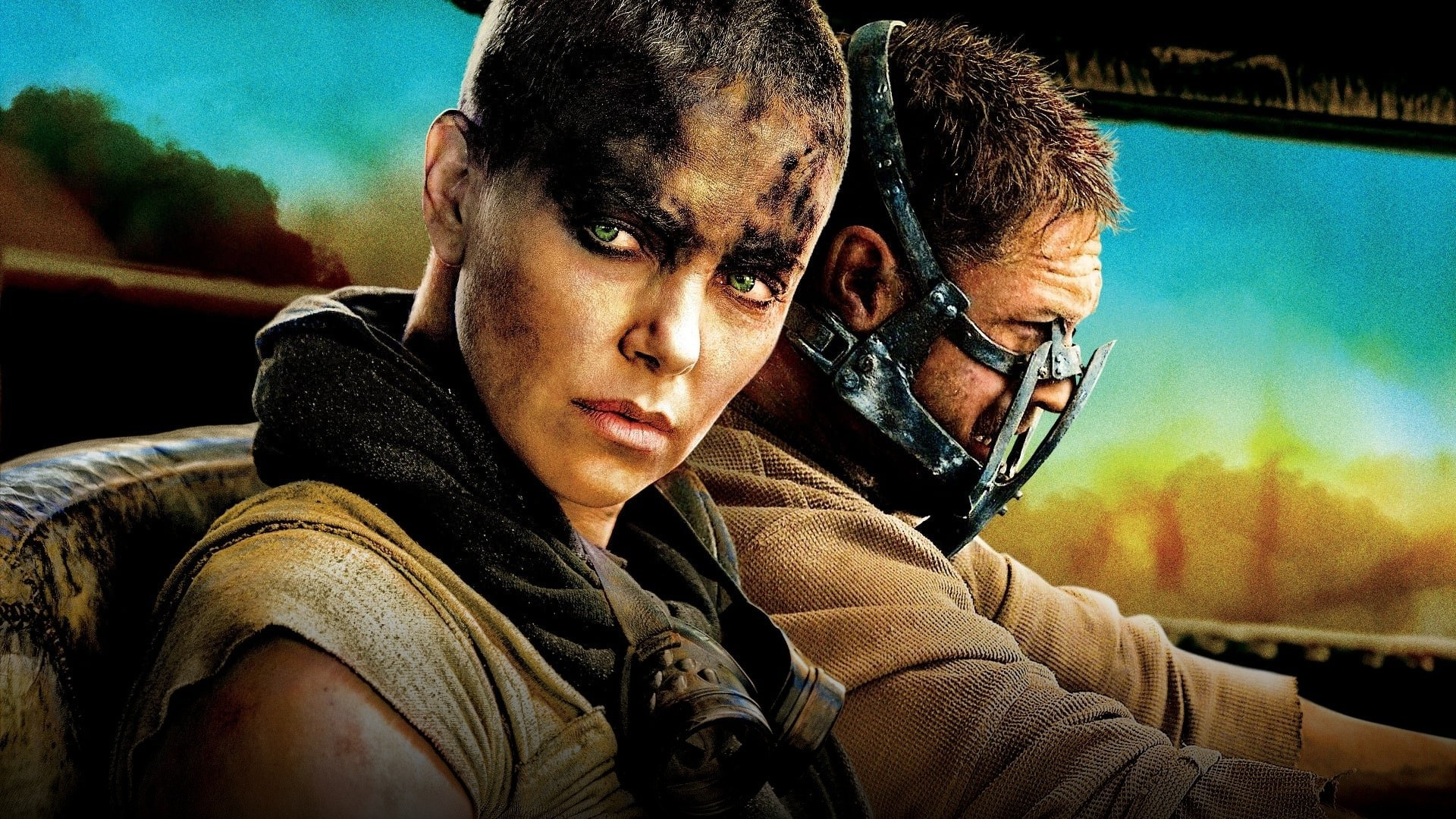 The War Rig speeds through a massive orange desert sandstorm pursued by armada vehicles in Mad Max: Fury Road.