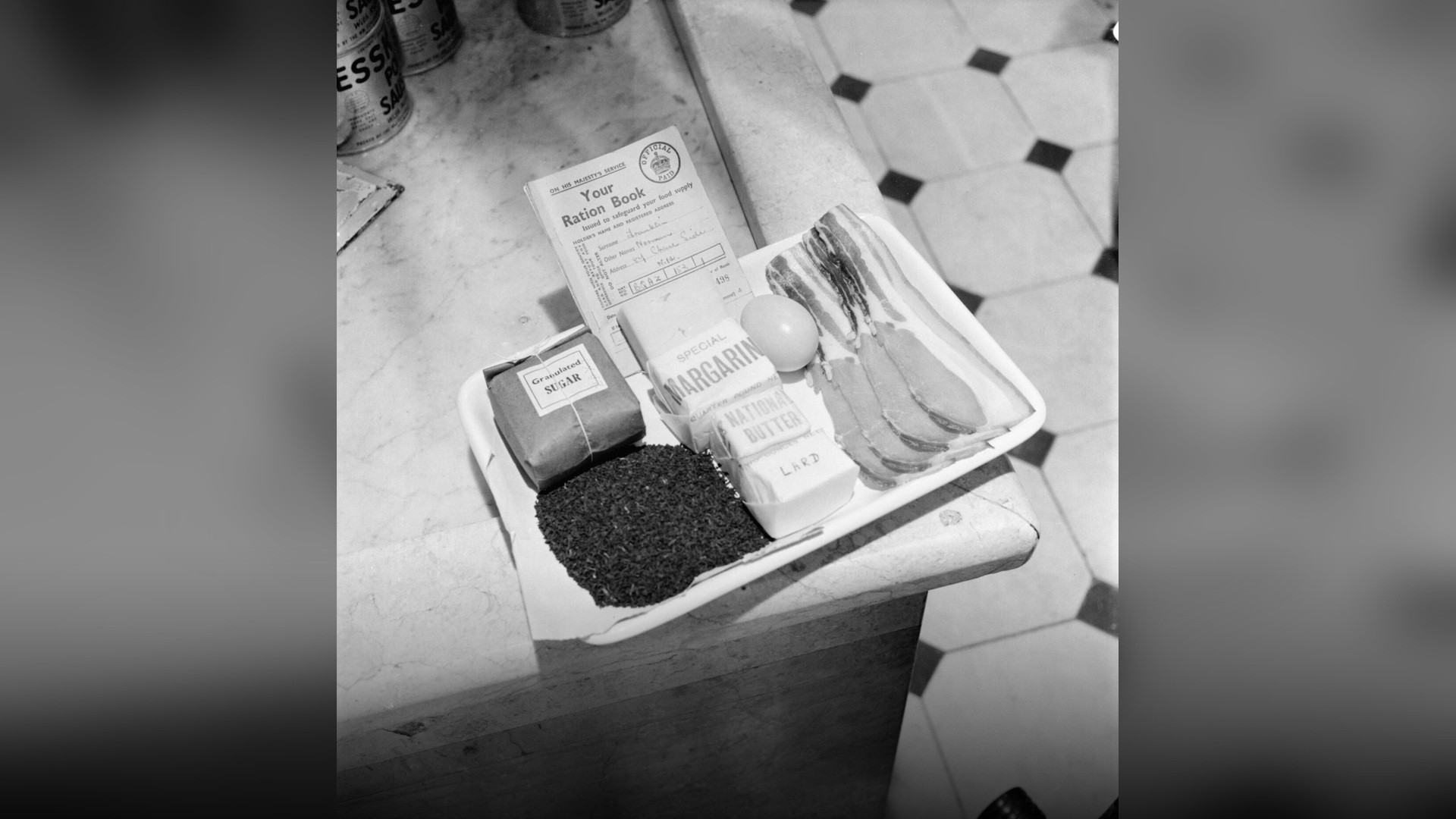 Historical wartime tray displaying an official sugar ration book alongside weekly civilian rations.