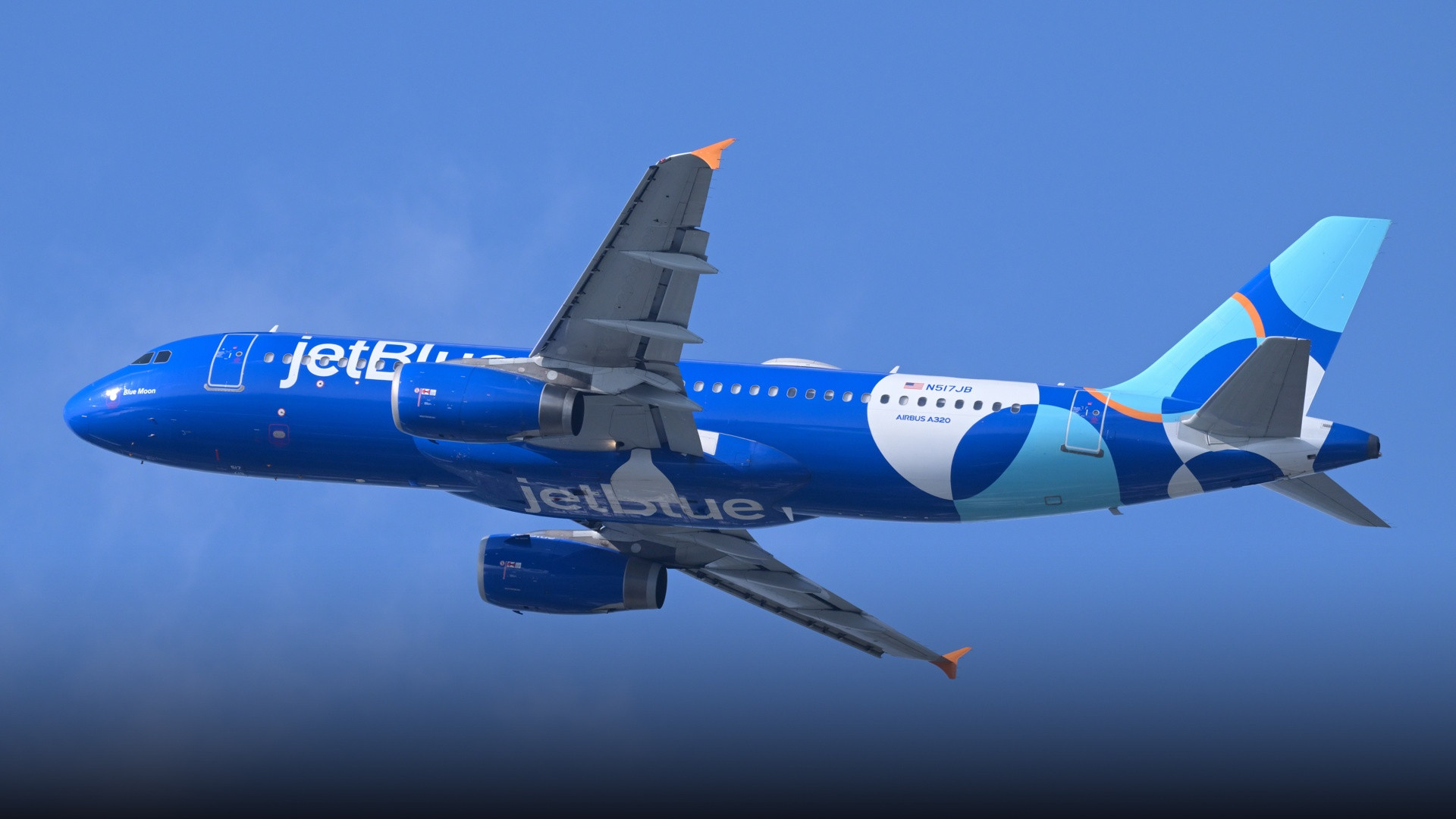 A JetBlue Airbus A320-232 climbing steeply into the sky showcasing its blue livery and sharklet wingtips.