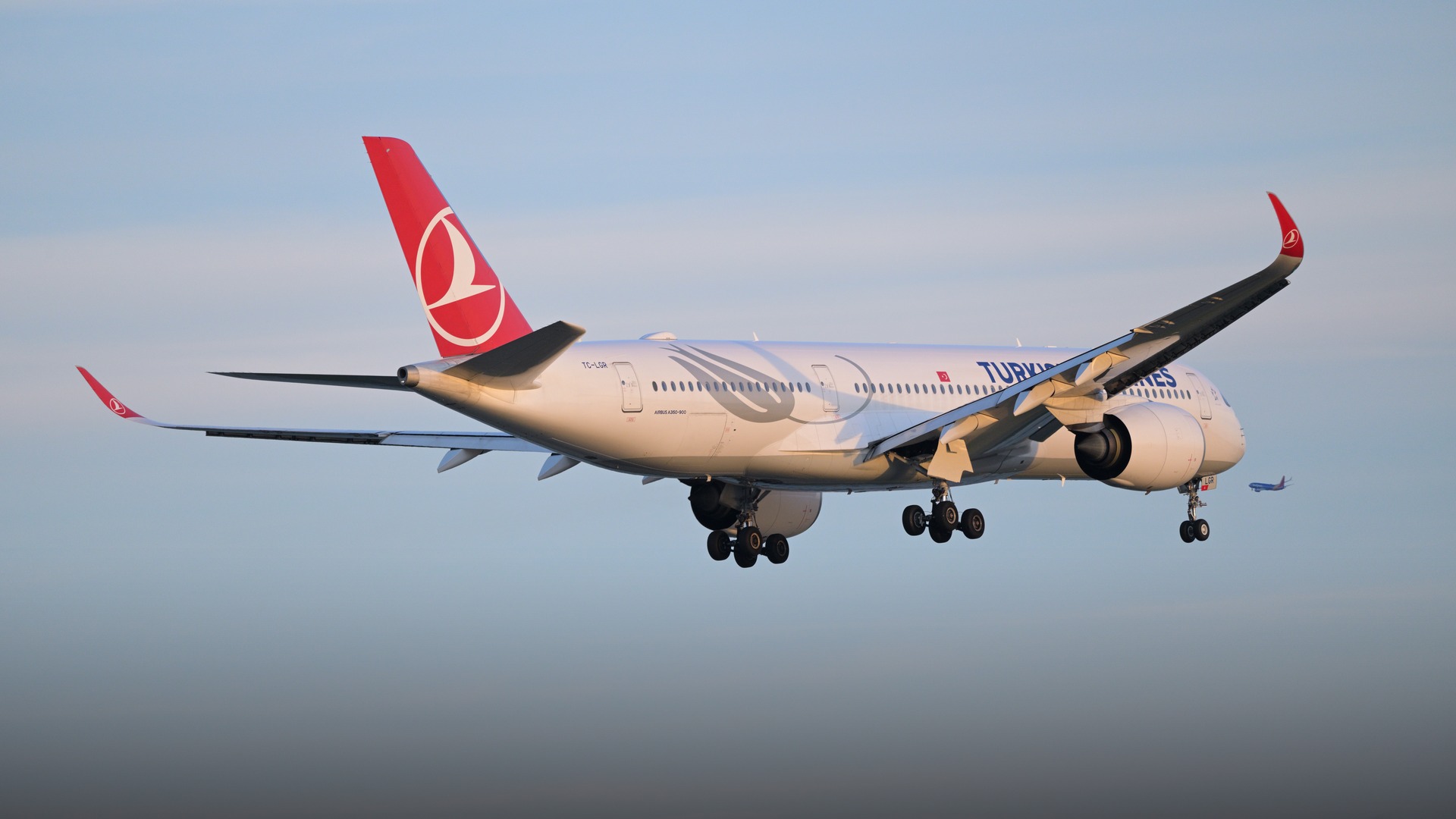 A Turkish Airlines Airbus A350-900 widebody aircraft featuring its iconic red tail emblem on final approach.