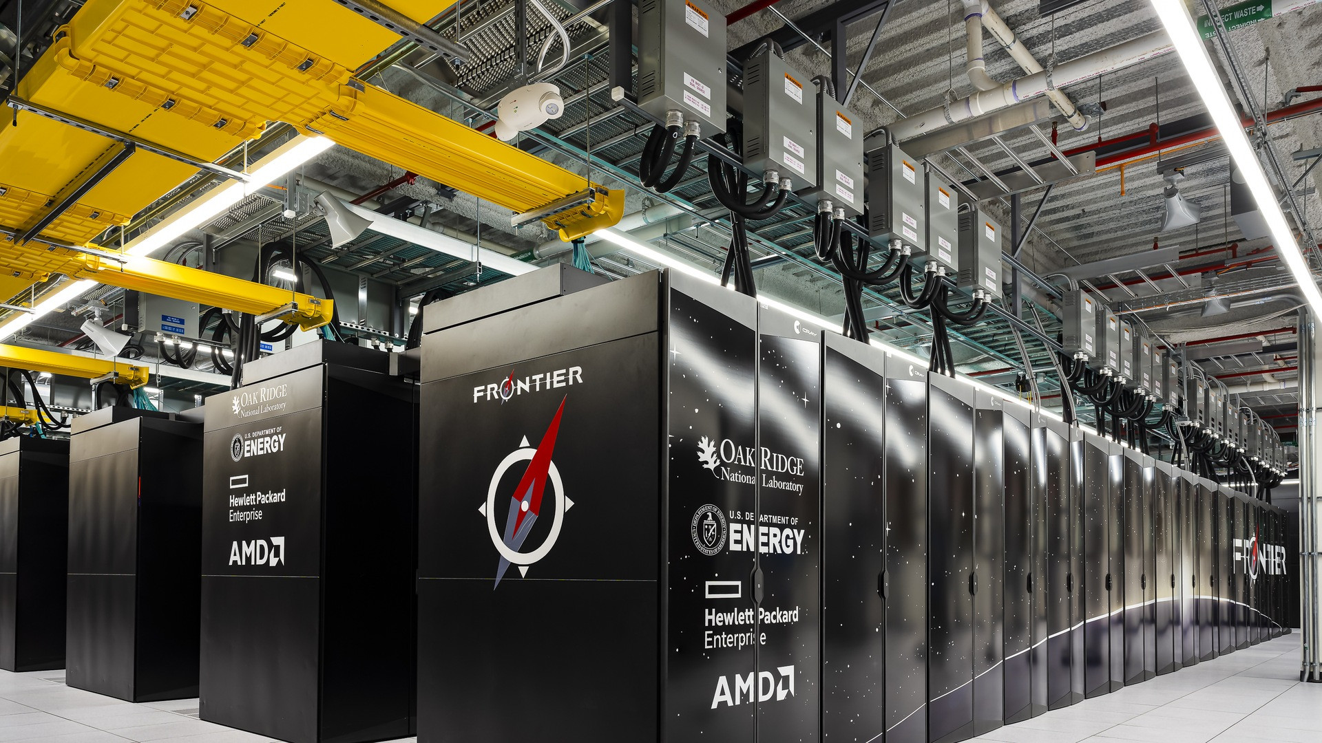 Glowing aisles of the Frontier exascale supercomputer at Oak Ridge National Laboratory with illuminated server cabinets.