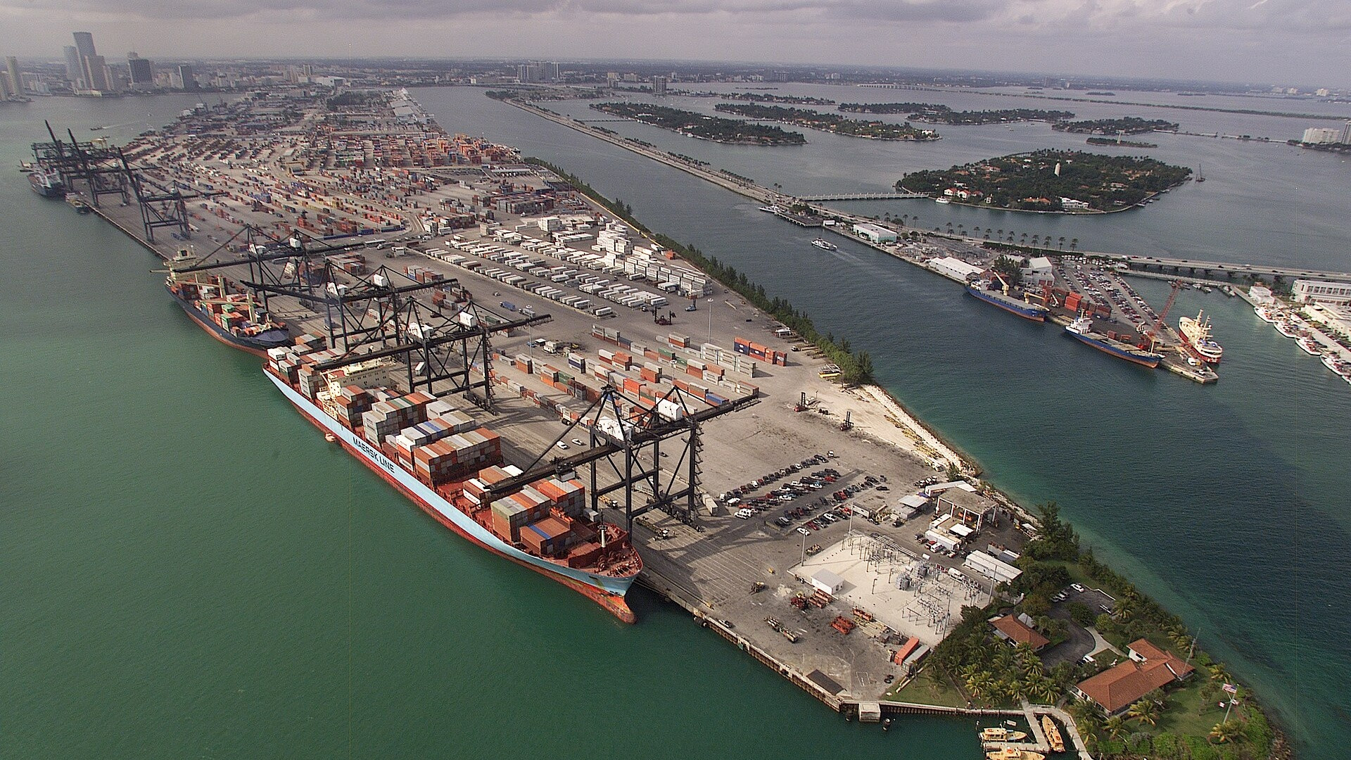 Aerial view of a major commercial cargo container shipping terminal and port cranes.