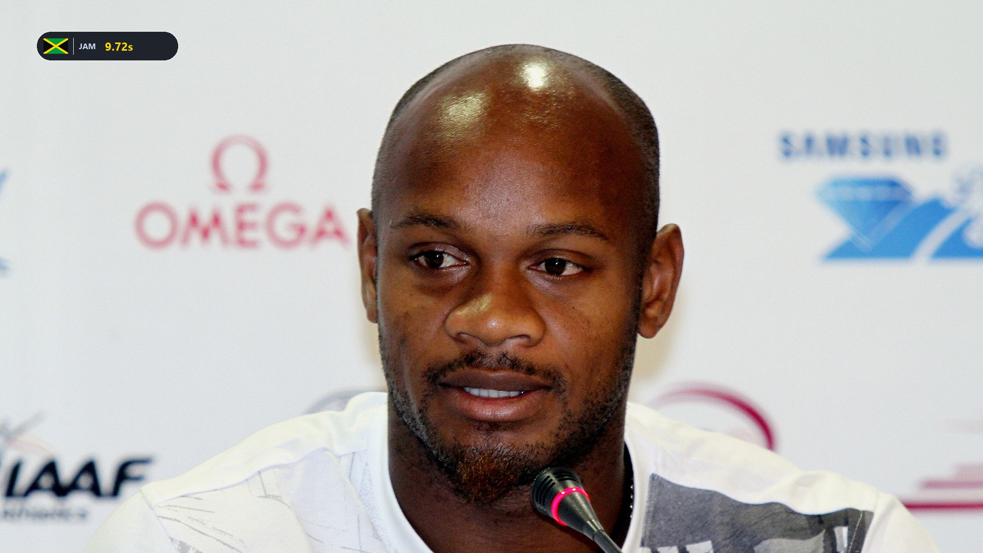 Asafa Powell speaking at an athletic press conference in Beijing.
