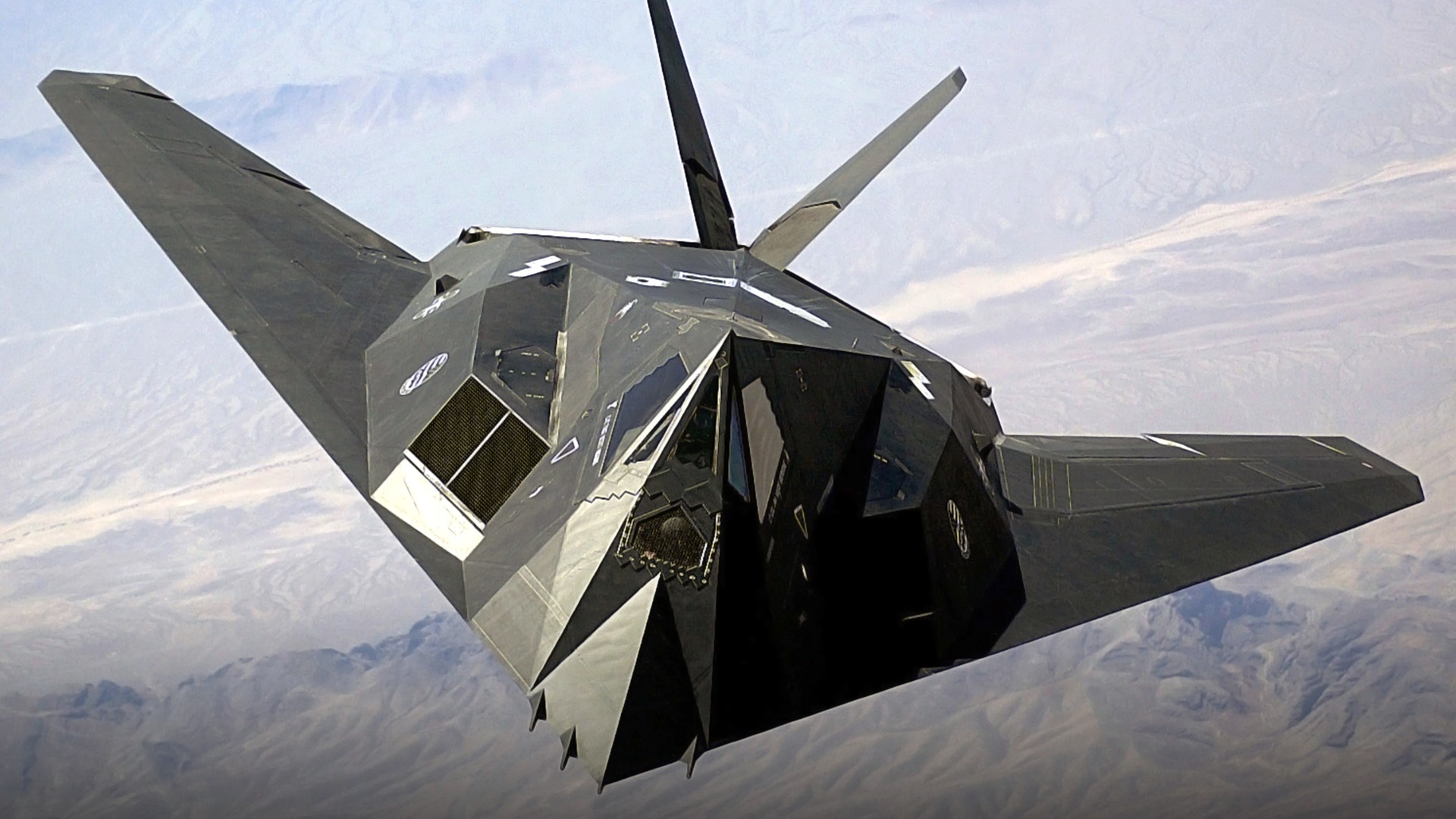 Head-on view of the black faceted Lockheed F-117 Nighthawk stealth attack aircraft.