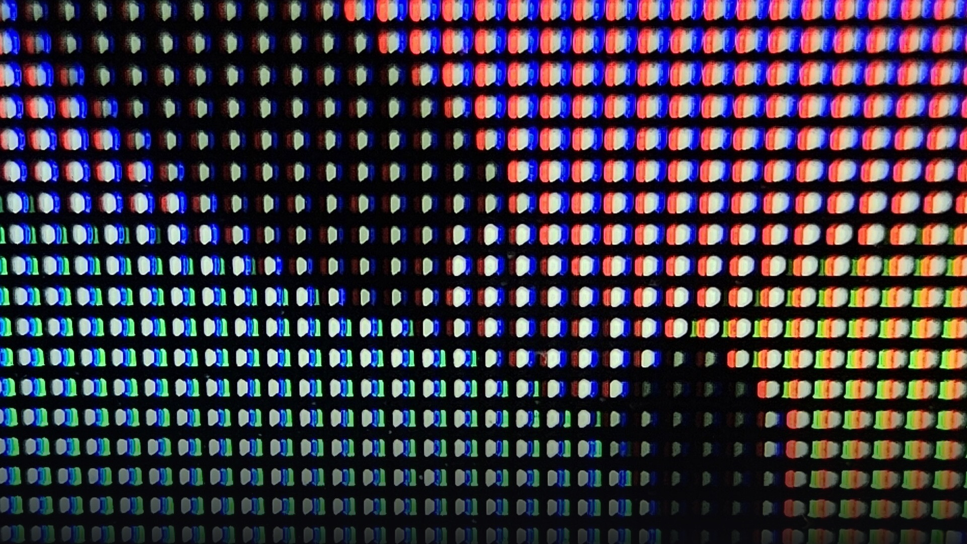 Macro photographic capture of microscopic OLED display subpixels illuminating deep black contrast.
