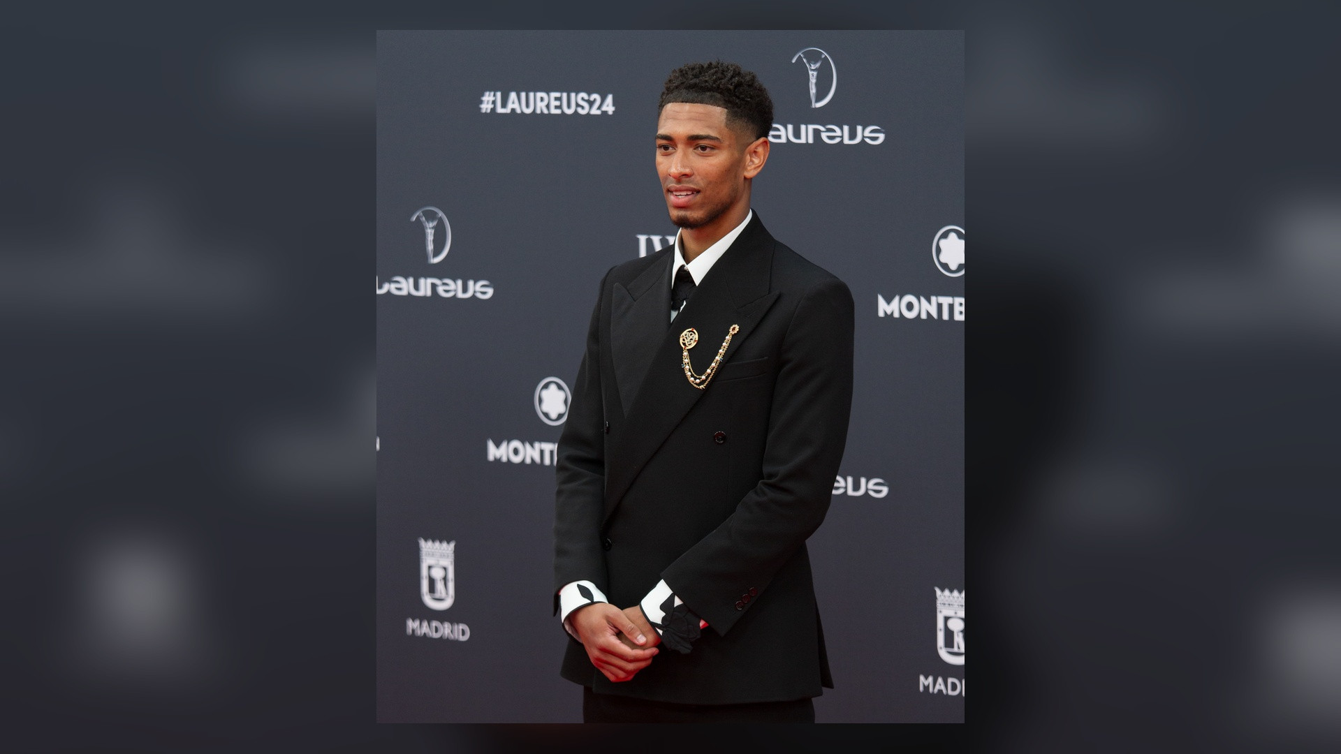Portrait of Jude Bellingham in a tailored black suit at an awards gala.