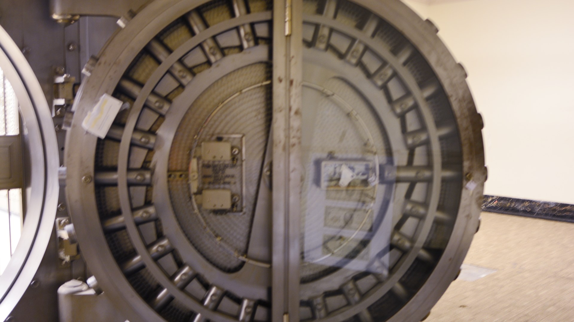 Reinforced steel vault door and security grille entrance to a bank safe-deposit room.
