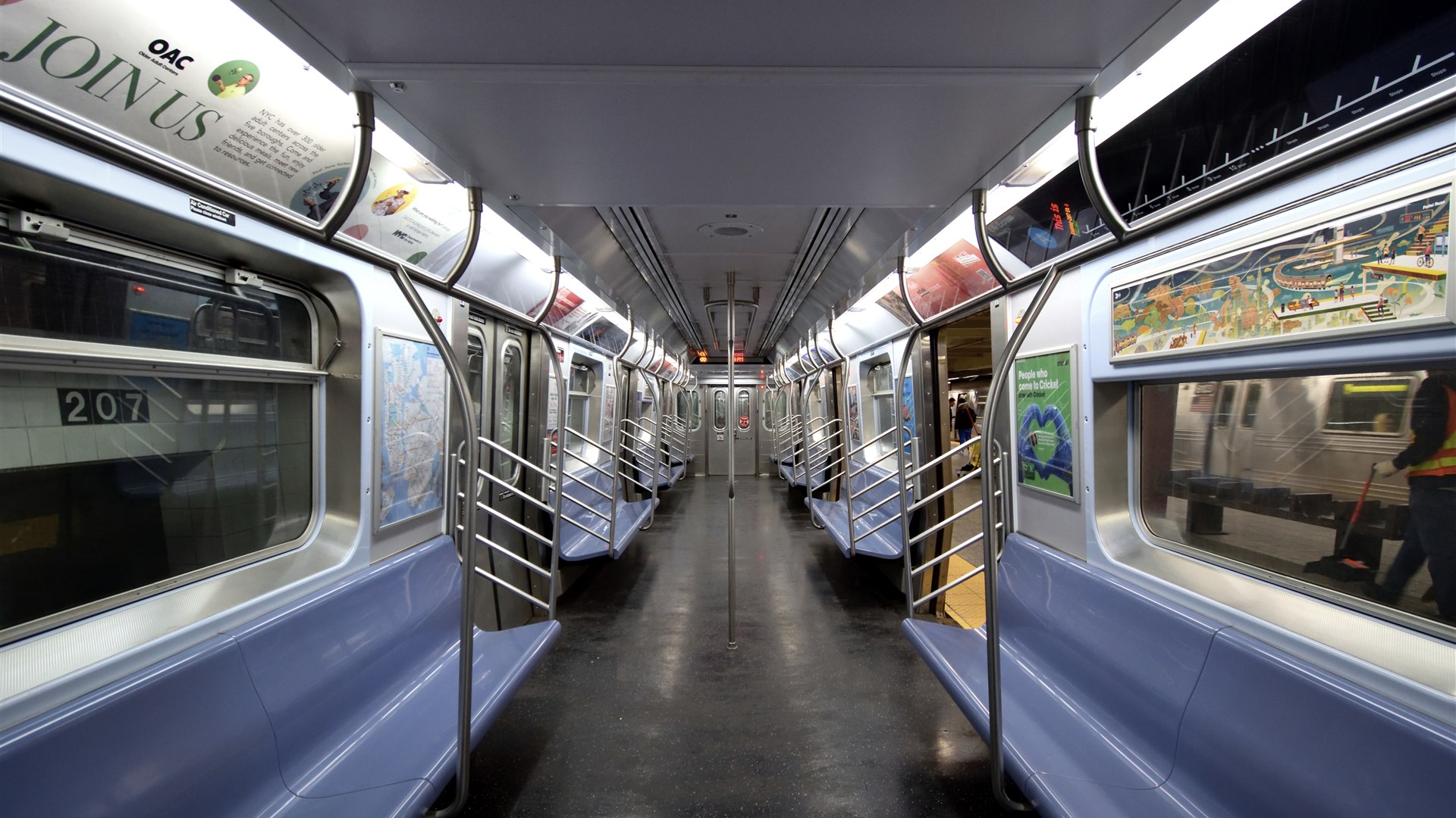 Empty New York City subway car interior with rows of orange seats