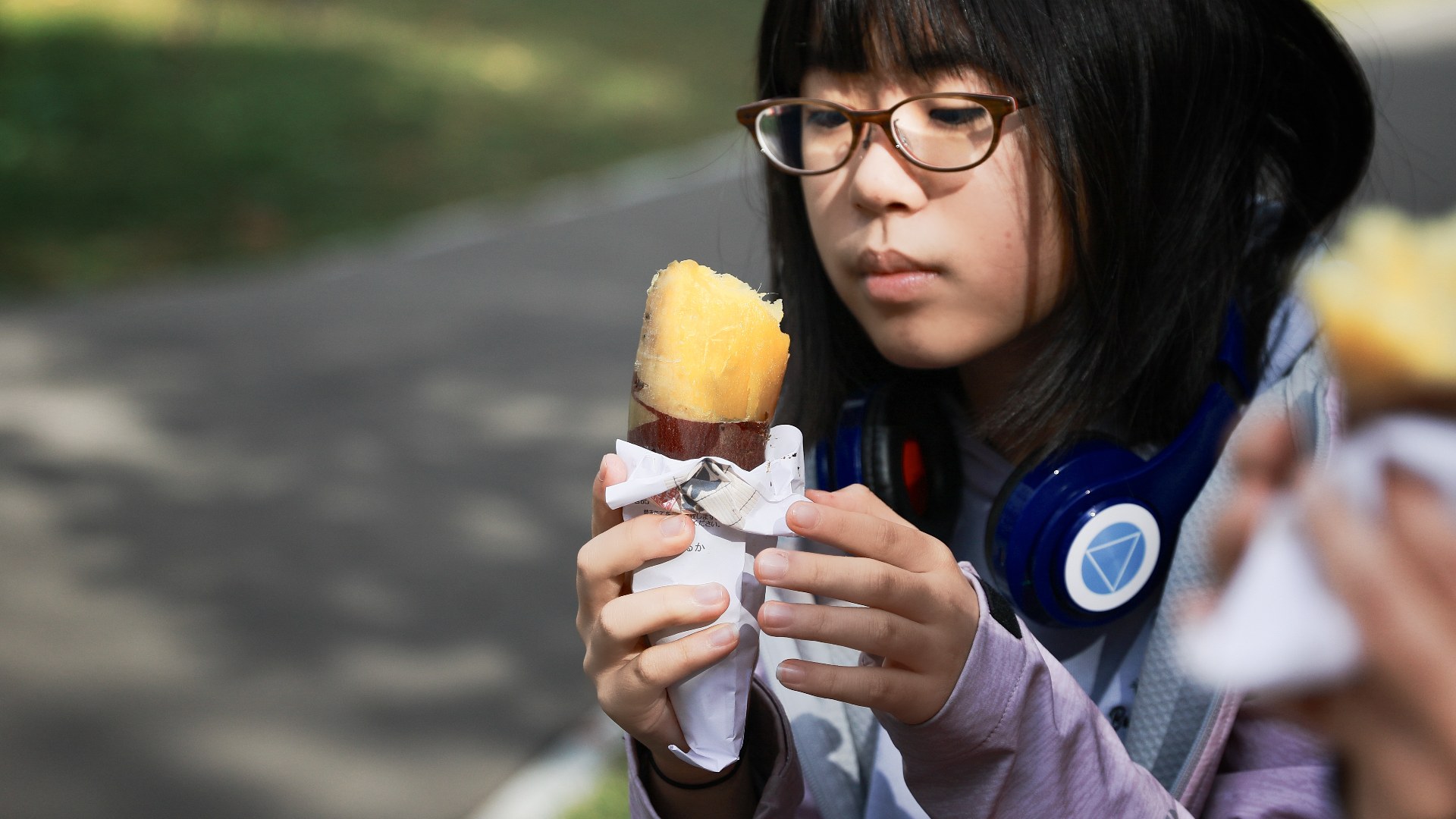 Person with headphones eating sweet food as part of sonic sensory taste modulation