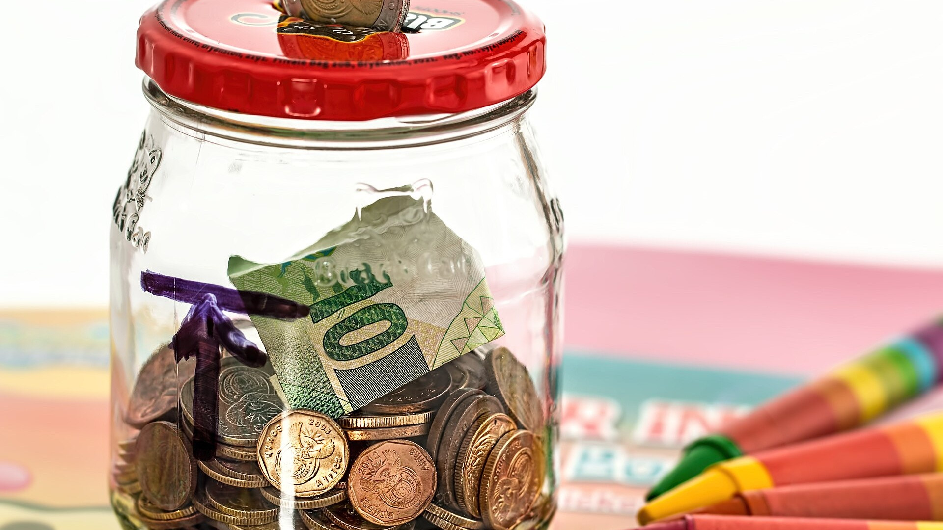 Traditional pink piggy bank with money savings coins.