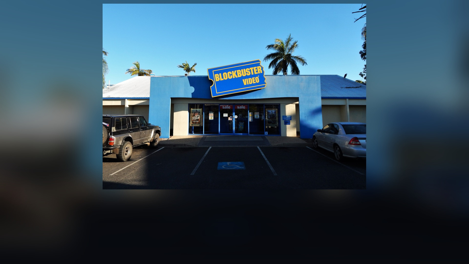 Exterior of a classic yellow and blue Blockbuster Video retail store.