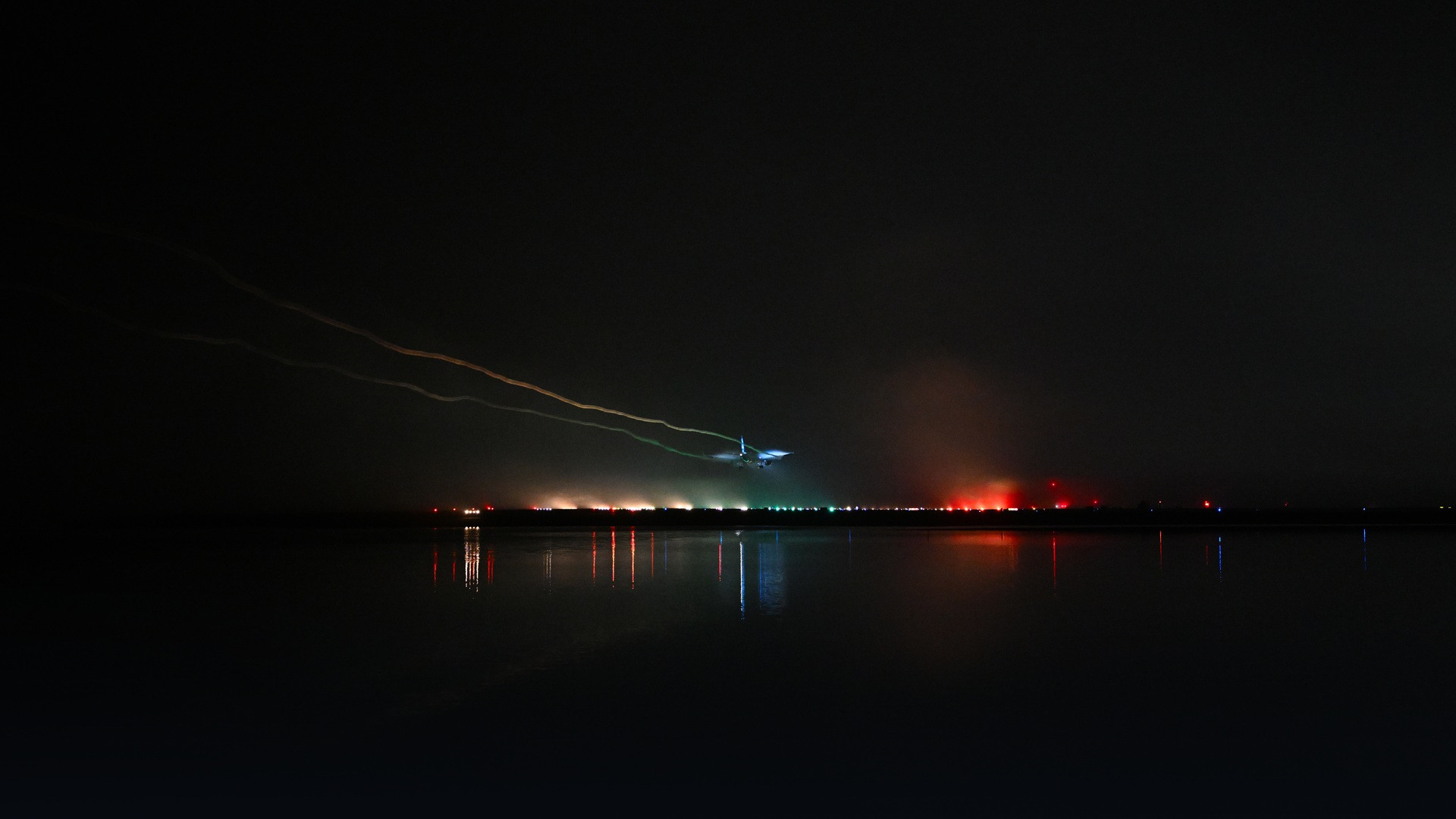 Commercial airliner emerging from dense fog during low-visibility runway landing.
