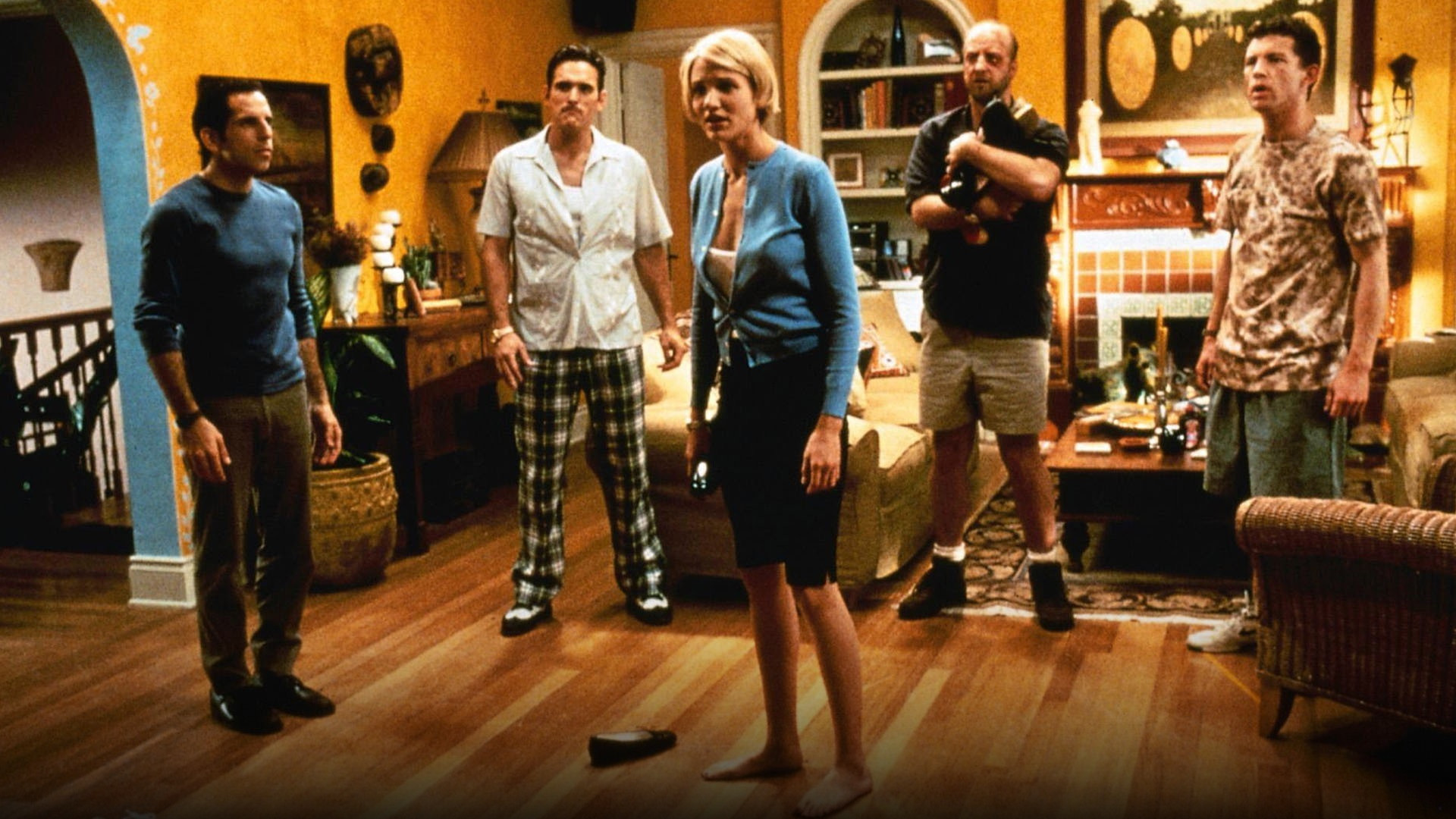 Cameron Diaz as Mary Jensen with an iconic hair styling mishap smiling across a table in There's Something About Mary.