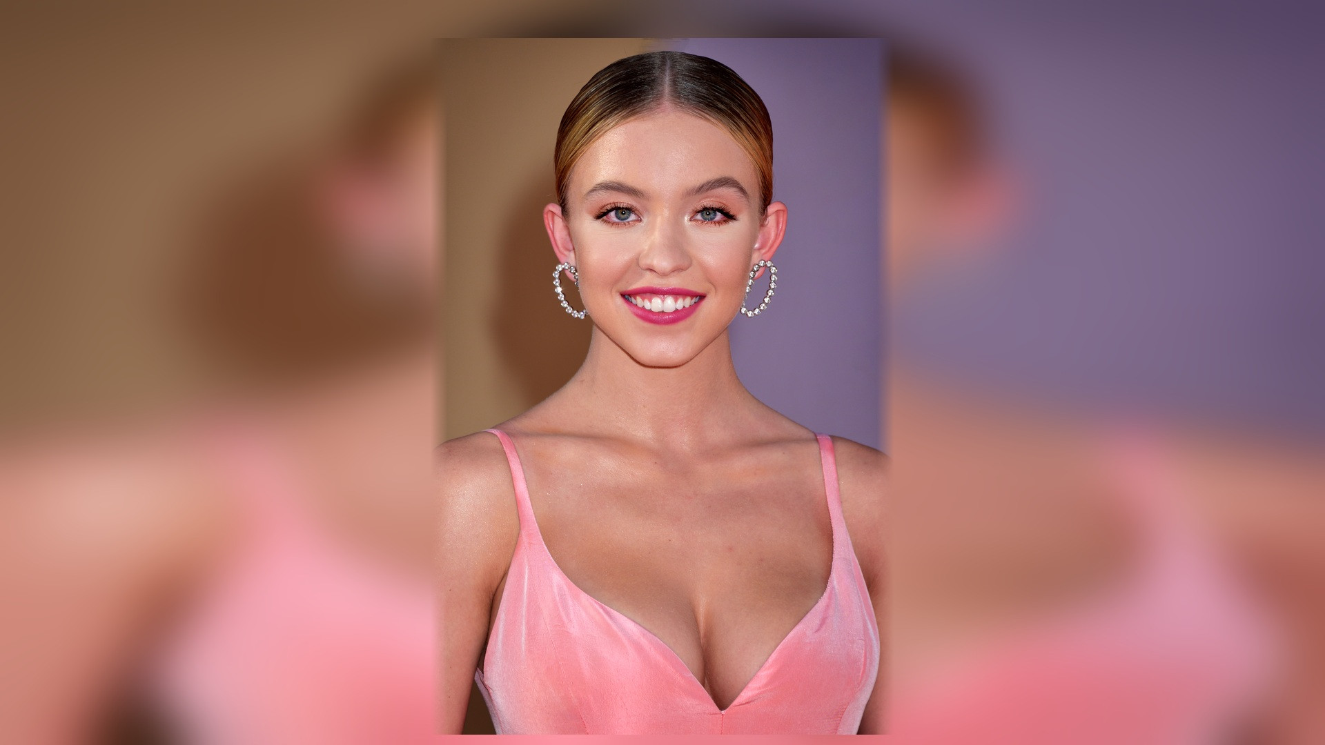 Full-length photograph of Sydney Sweeney in a black and yellow patterned dress on the red carpet.