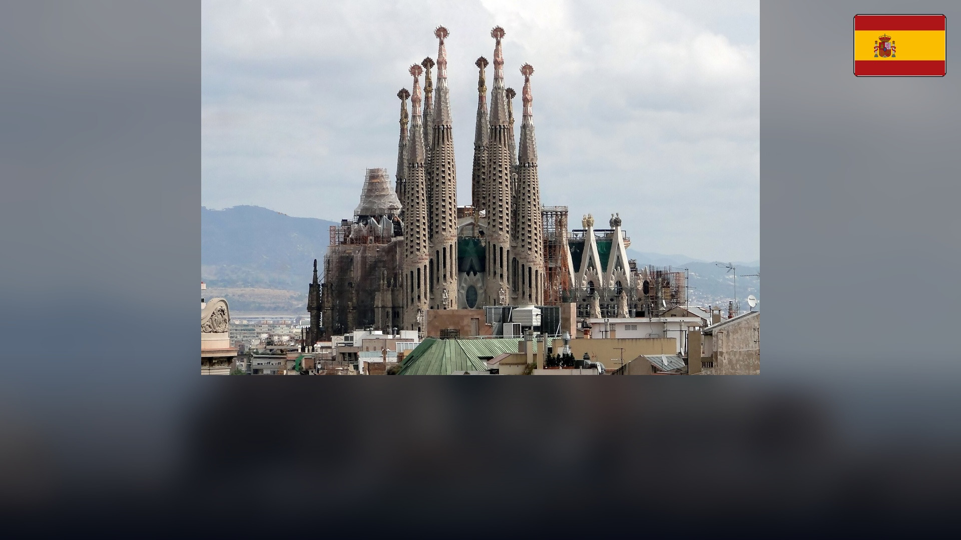 Basílica de la Sagrada Família in Barcelona with the Spanish flag in the top right corner.