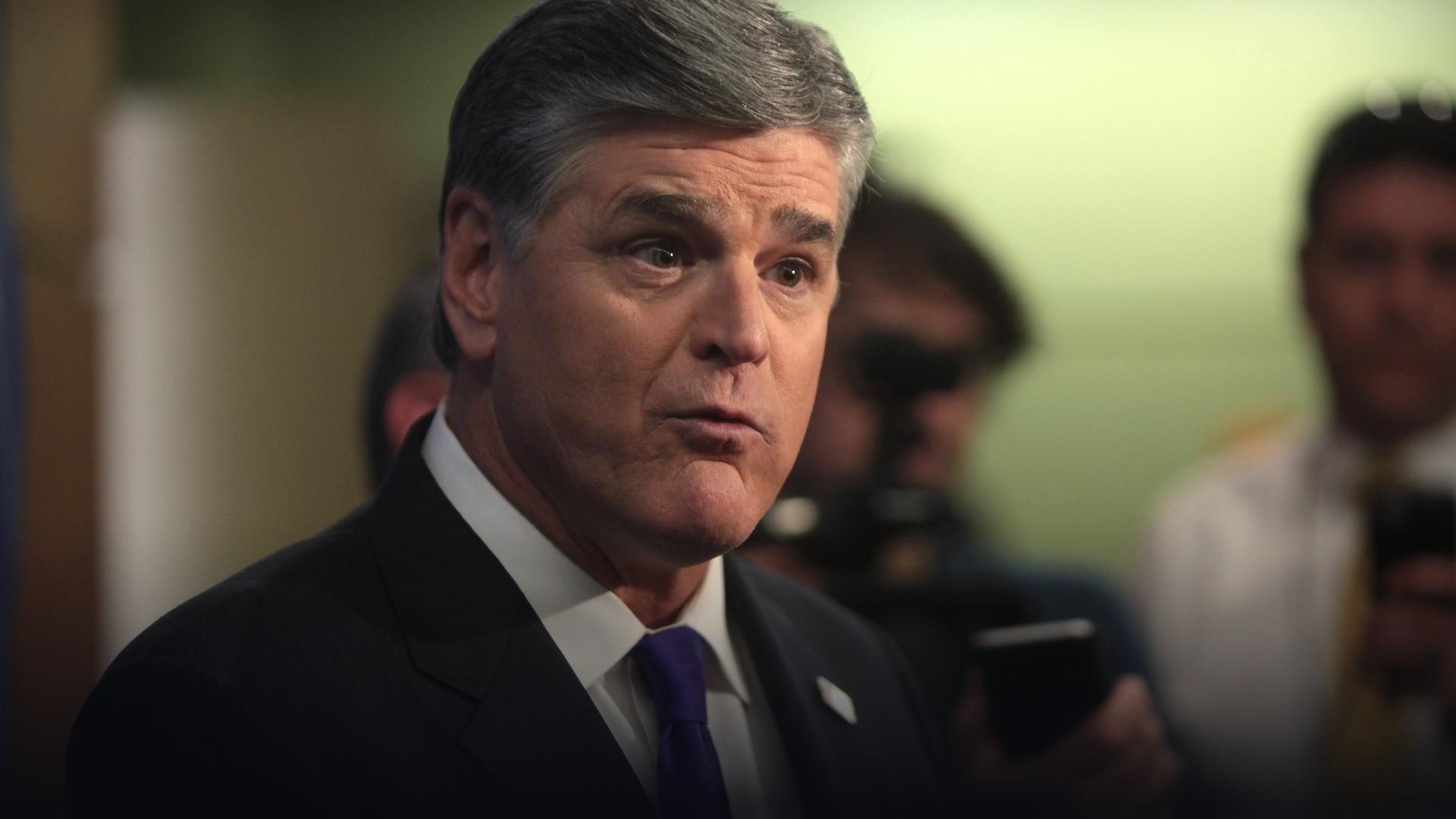 Fox News host Sean Hannity in a dark suit and tie speaking during a broadcast appearance.