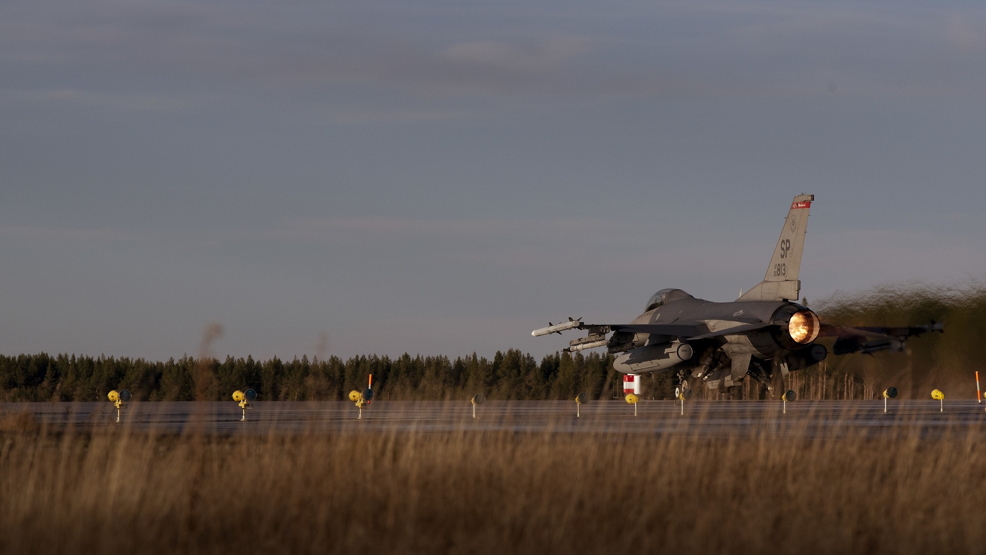 U.S. Air Force F-16 Fighting Falcon fighter jet taking off with afterburner firing.