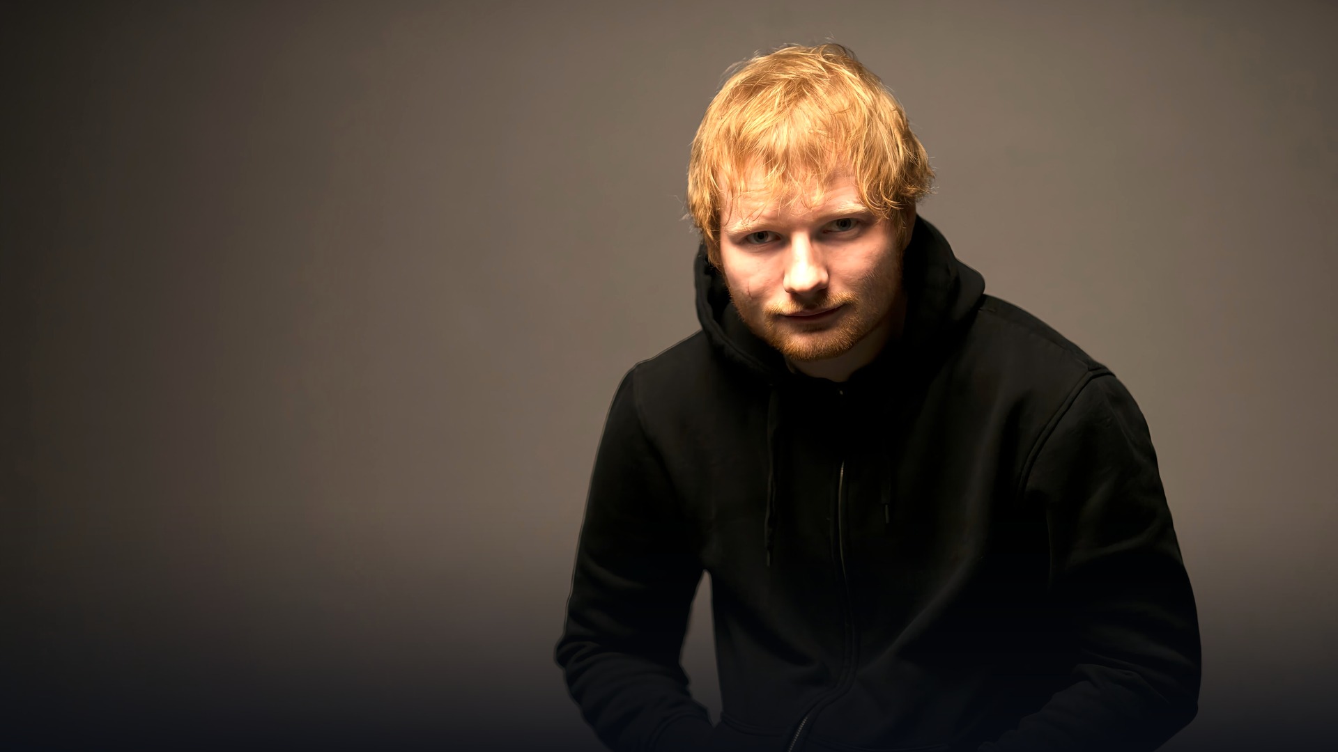 Ed Sheeran portrait in warm cinematic lighting.