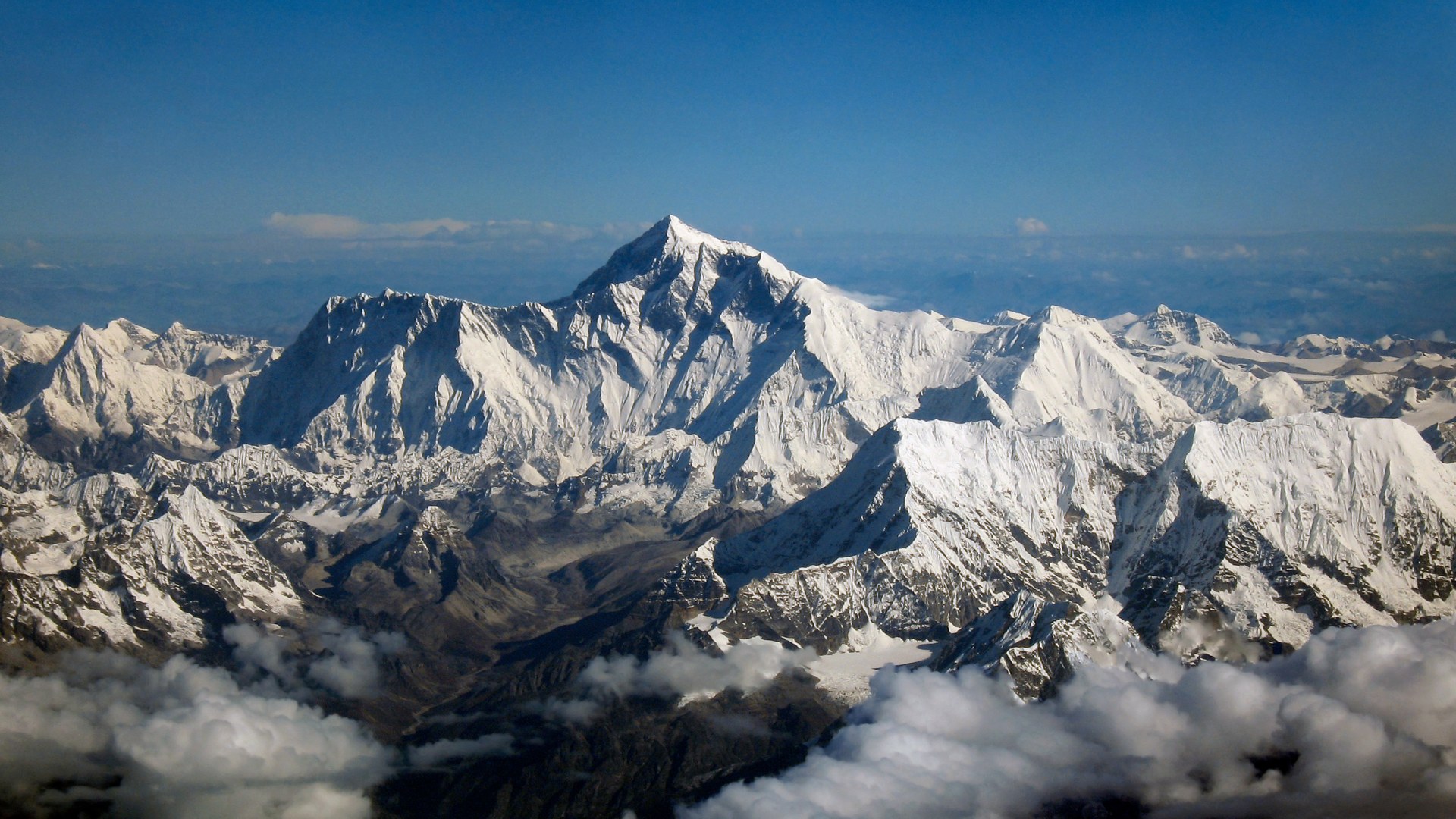 Landscape aerial view of the snow-capped Mount Everest summit pyramid straddling the border between Nepal and China.