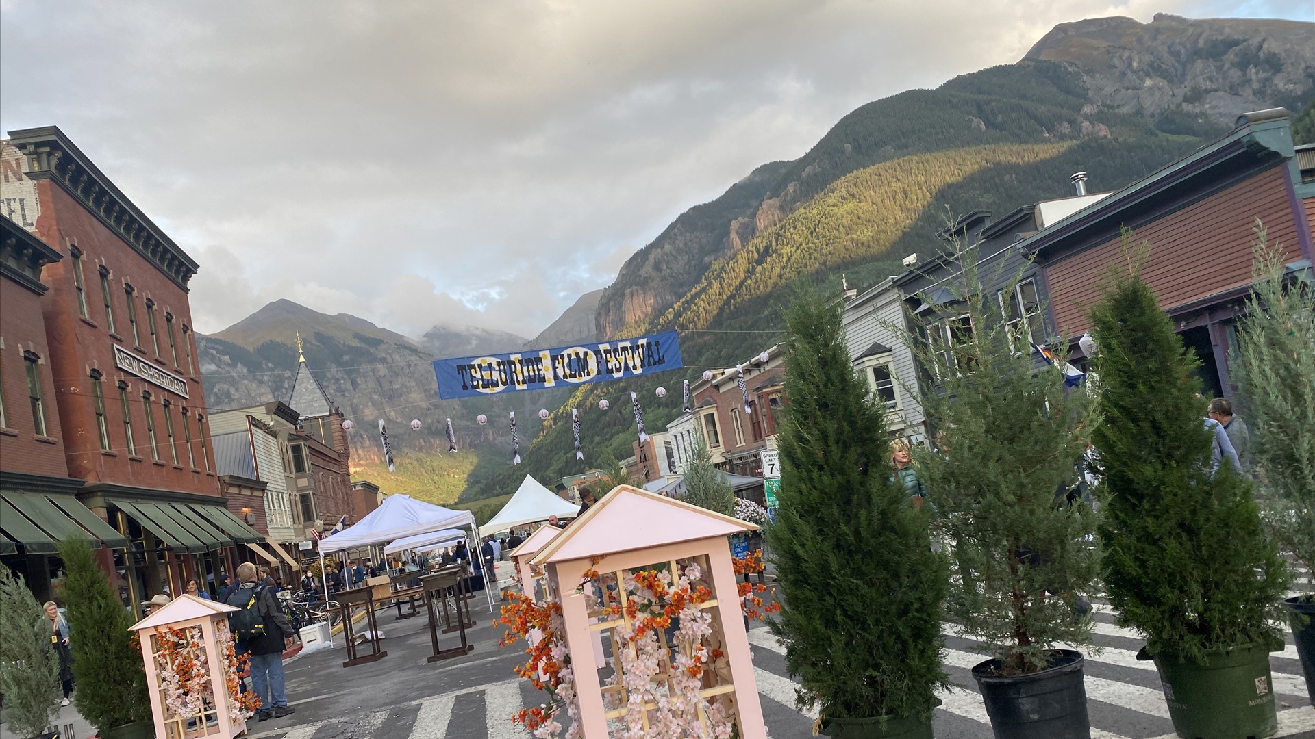 Historic Victorian buildings along Colorado Avenue framed by towering box canyon walls in Telluride, Colorado