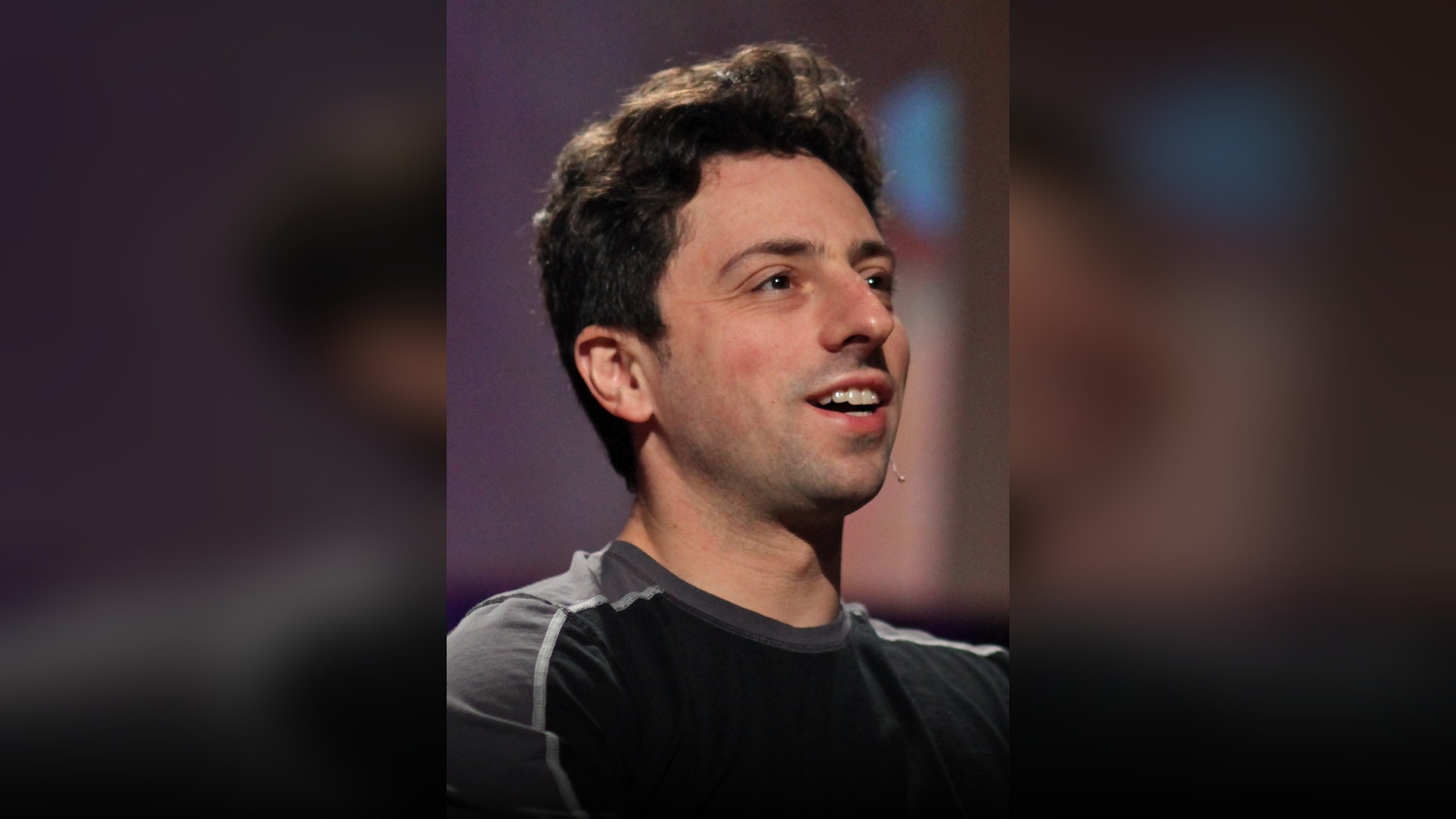 Sergey Brin smiling at a technology keynote.