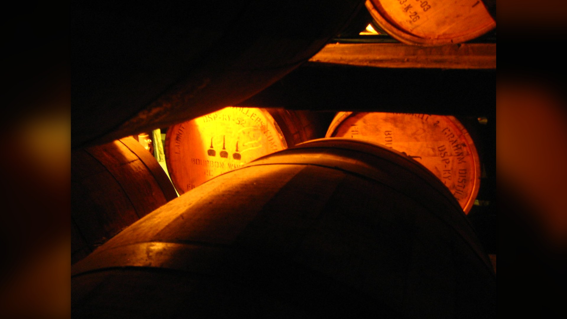 Wooden bourbon barrels aging in a Kentucky distillery rackhouse