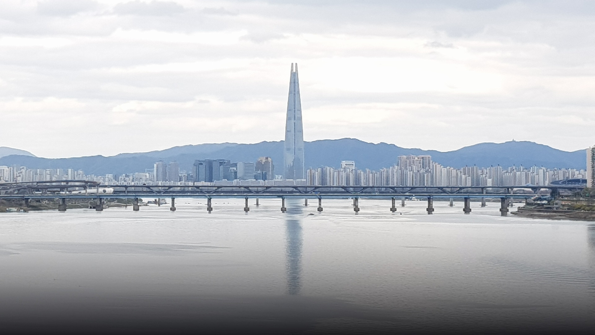 Lotte World Tower towering above the Seoul cityscape viewed from the Seongsu Bridge.