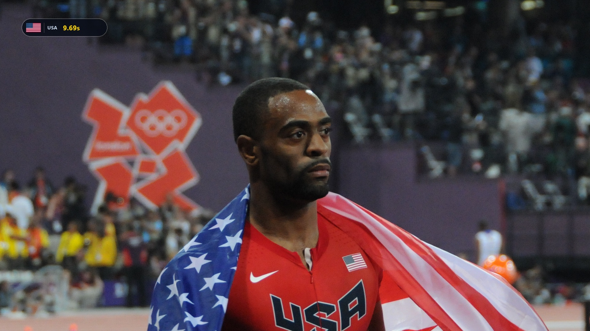 Tyson Gay draped in the American flag wearing his red USA Olympic speedsuit.